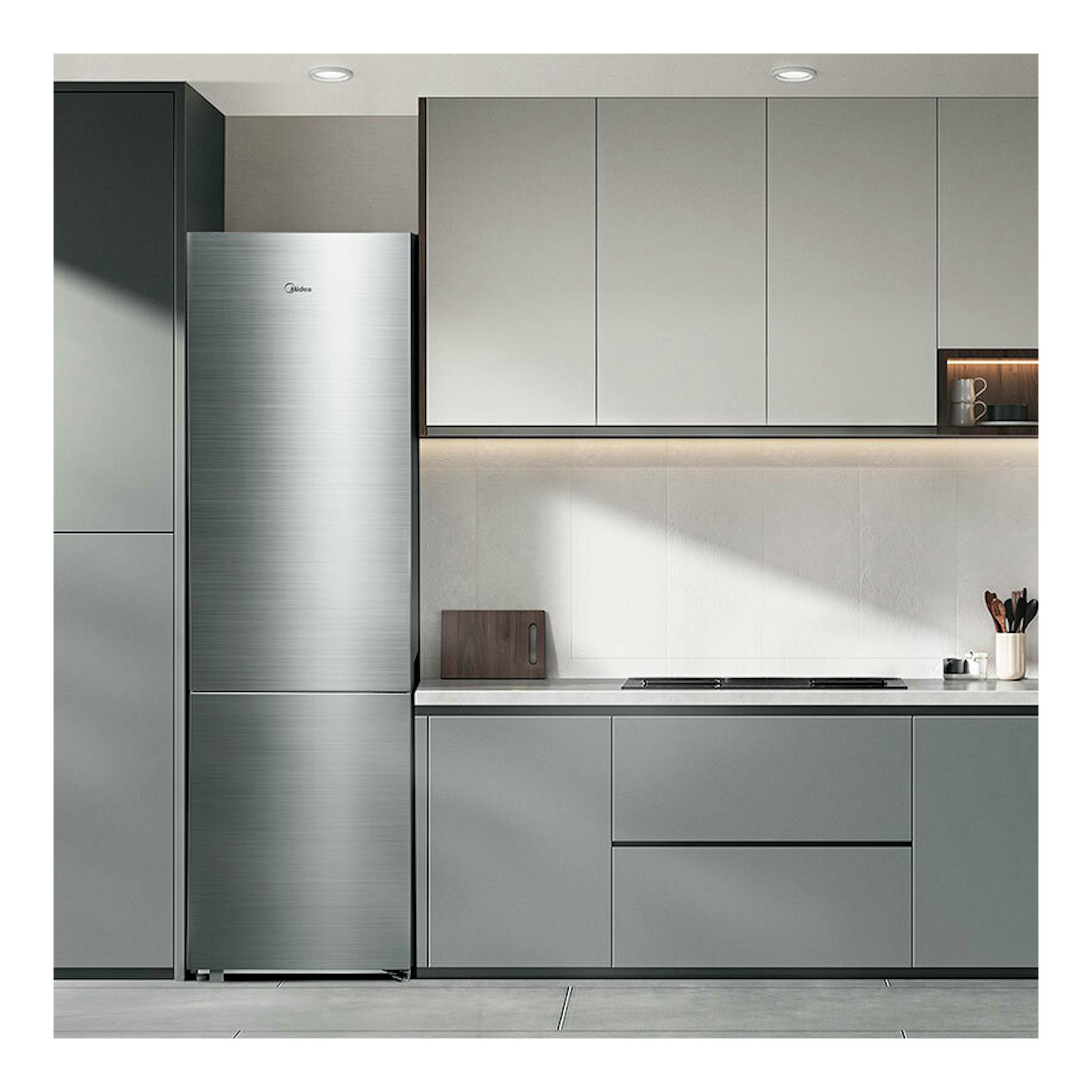 Frigorífico combi Midea MDRB600MME46 inox, vista frontal, junto a muebles grises de cocina moderna.