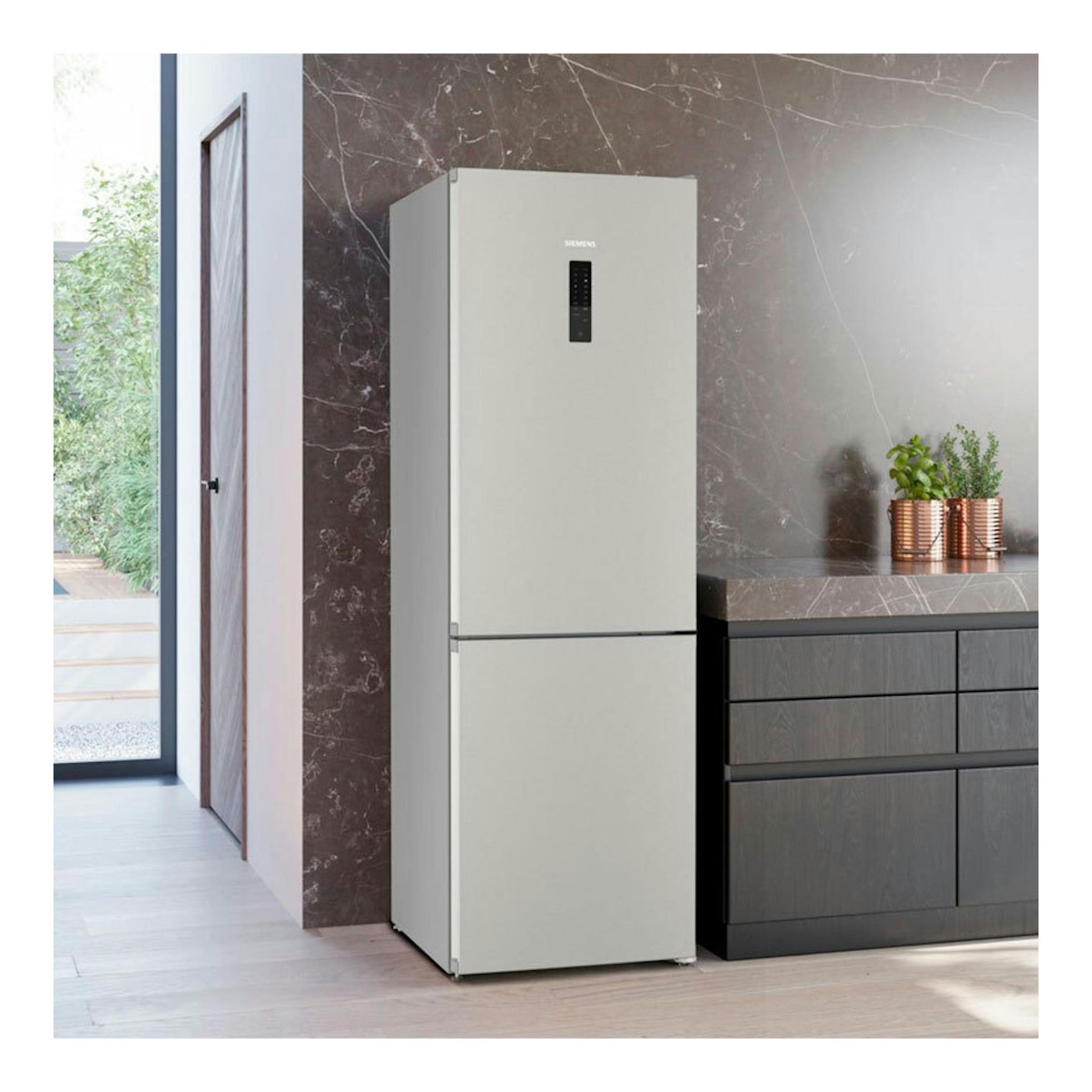 Frigorífico combi Siemens inox, vista frontal, junto a muebles oscuros en cocina moderna.