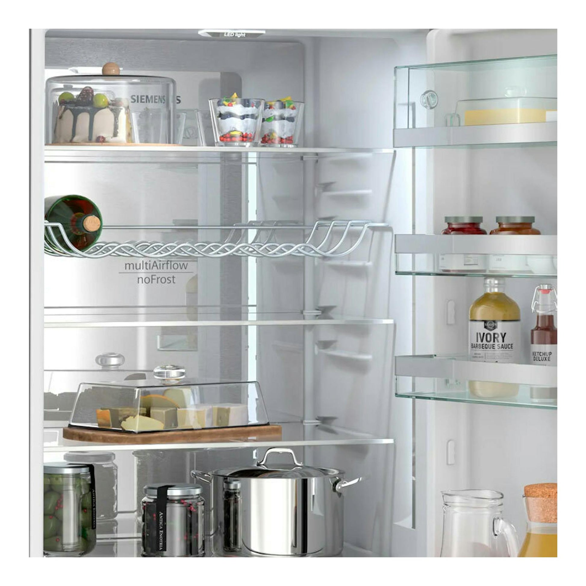 Interior de frigorífico Siemens KG39N4X1F, vista frontal, con estantes de vidrio y alimentos.