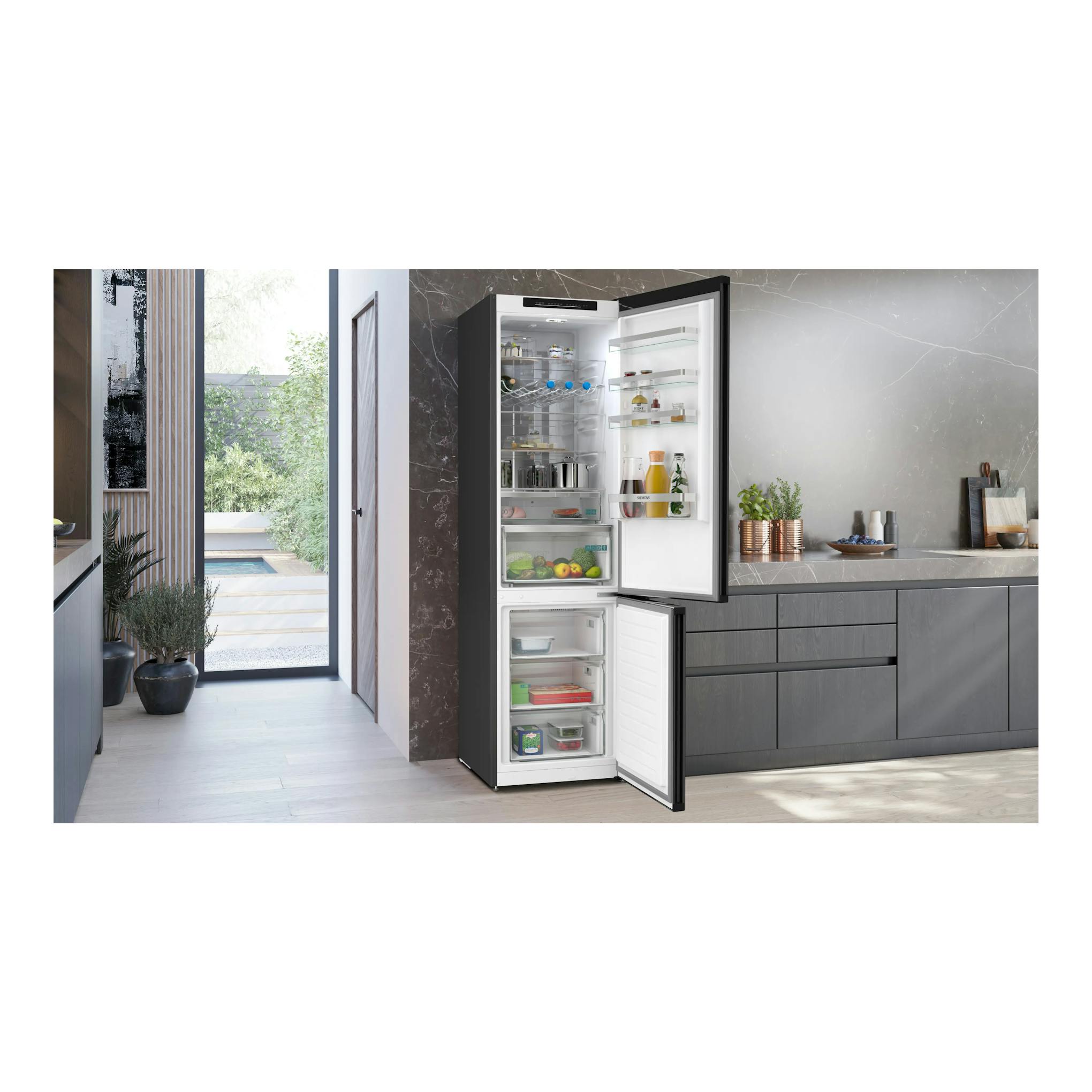 Frigorífico combi Siemens KG39NVXCG negro, con la puerta abierta y vista frontal del interior en una cocina moderna.