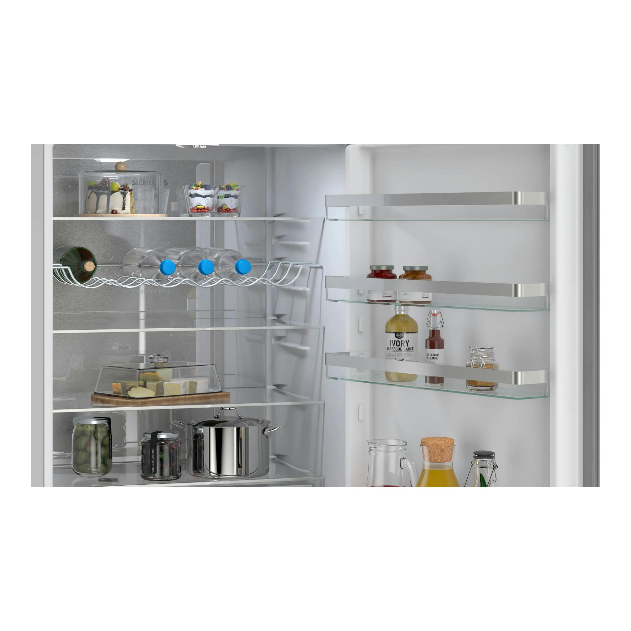 Interior de frigorífico combi Siemens KG49NVIDG en inox, vista frontal abierta, con estantes de vidrio.