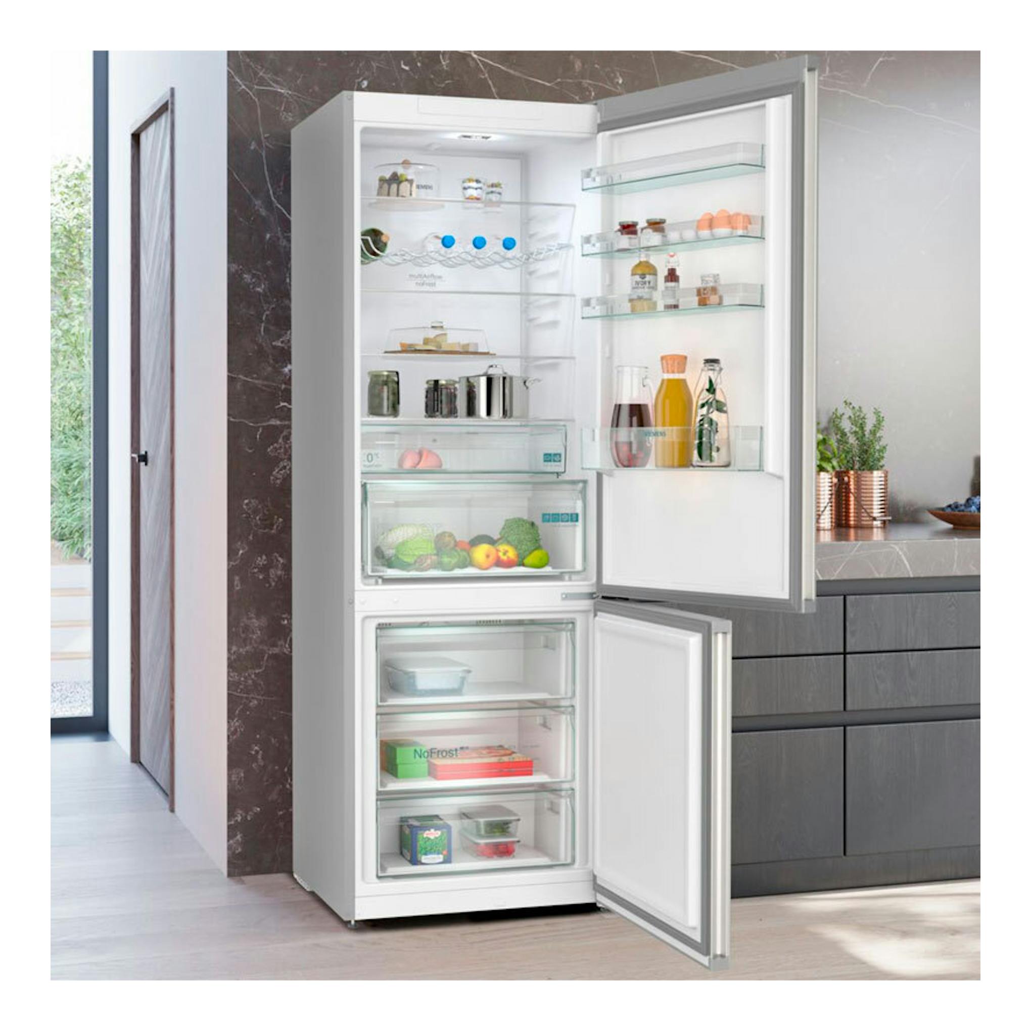 Frigorífico combi Siemens KG49NXIDF inox, vista frontal con puertas abiertas y compartimentos visibles.