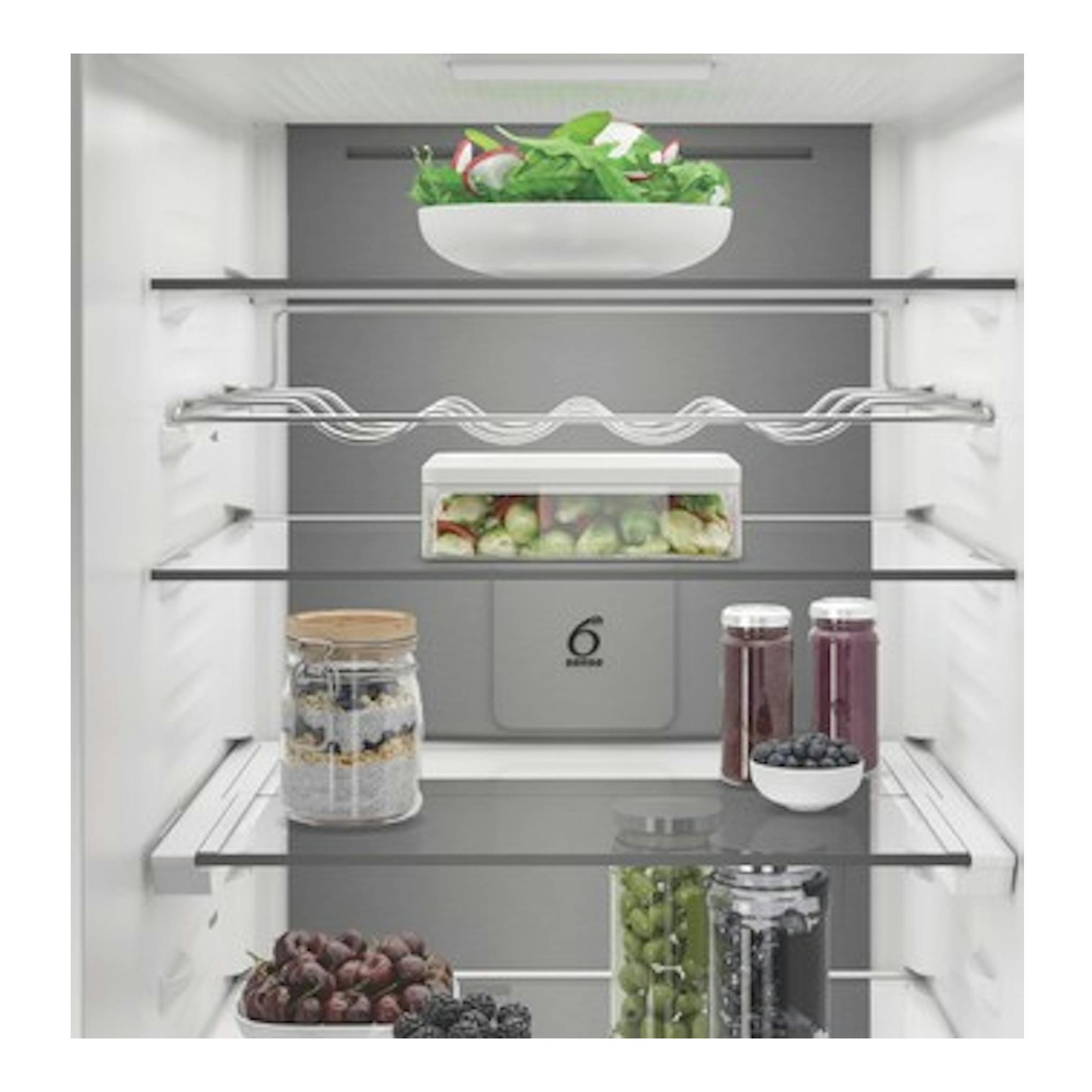 Interior de frigorífico combi Whirlpool WHK 26412 X5EE1 gris, vista frontal, con estantes de cristal y alimentos.
