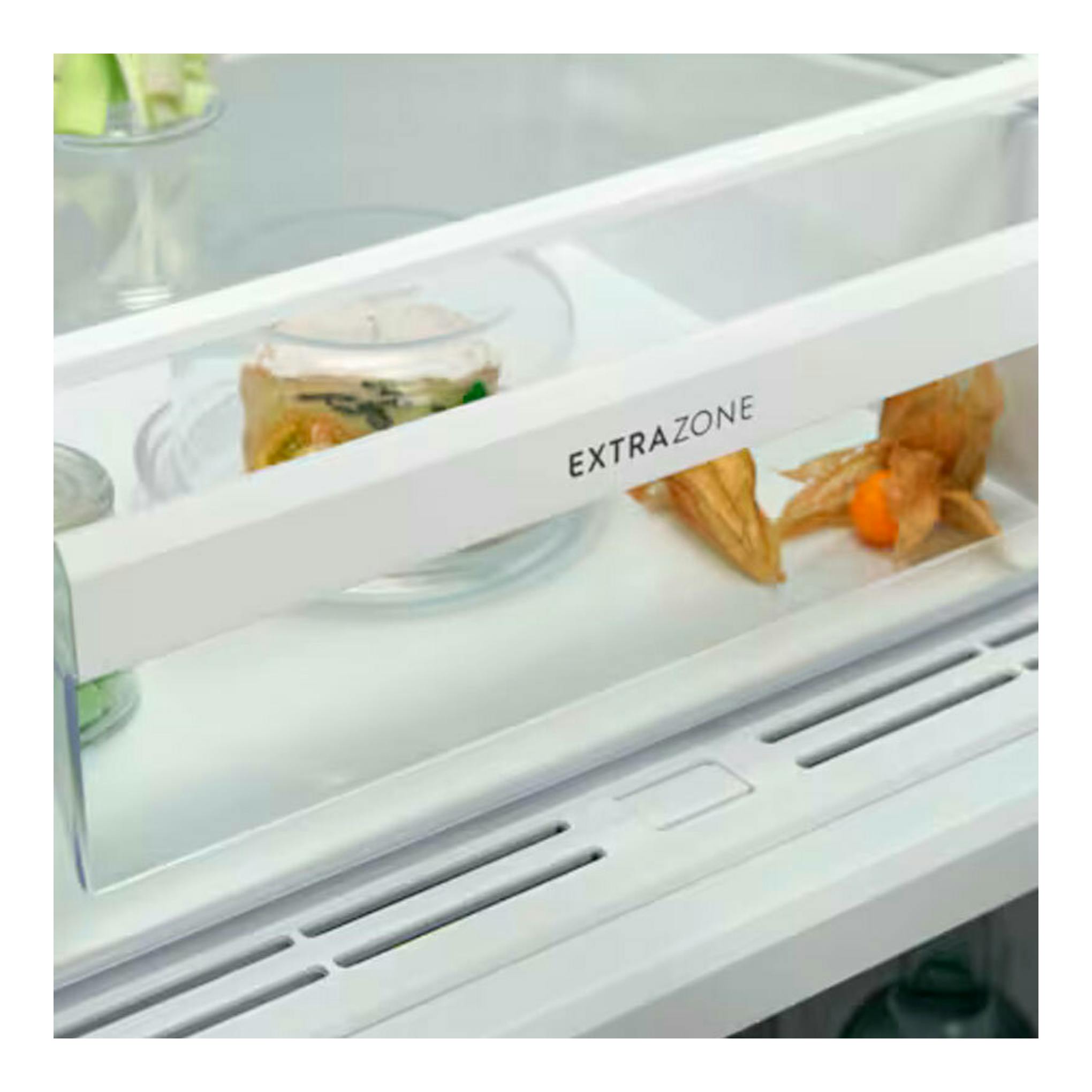 Interior de frigorífico integrable blanco Electrolux ERD6DE18S1, cajón ExtraZone con alimentos, vista frontal.