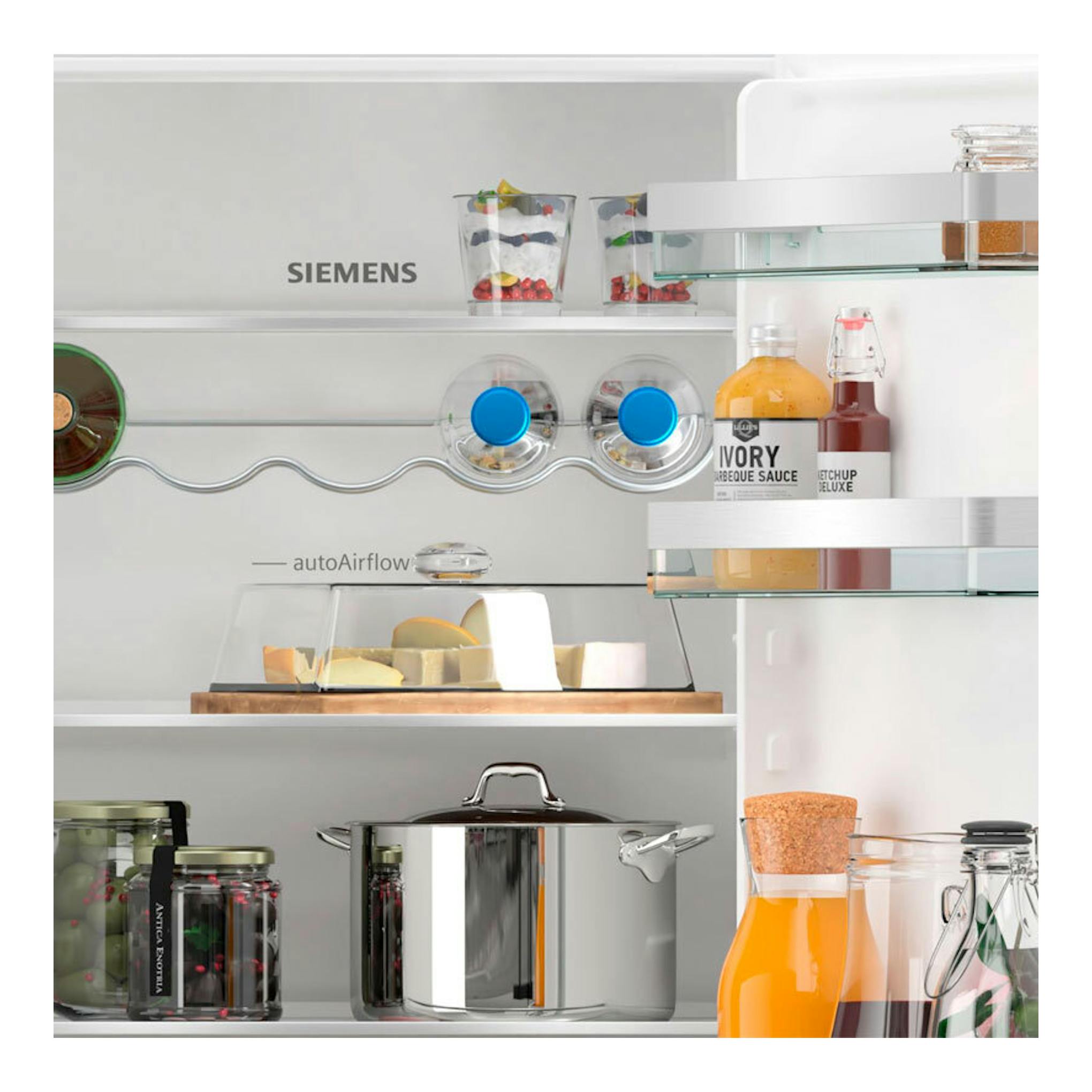 Interior de frigorífico integrable Siemens KI86NVSE0, vista frontal, con estantes y alimentos.