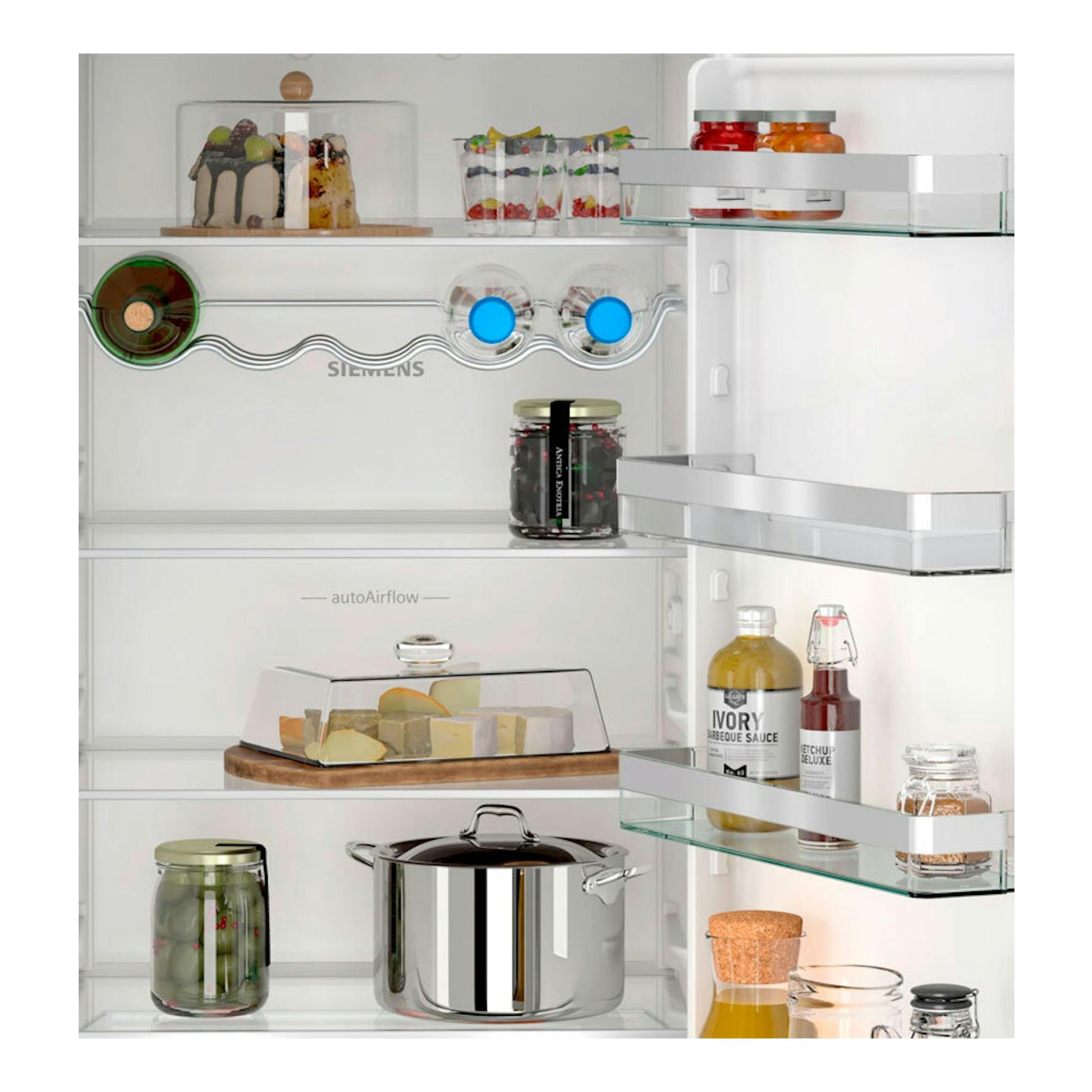 Frigorífico integrable Siemens KI86VVSE0 abierto, vista frontal del interior blanco con estantes de cristal y alimentos.