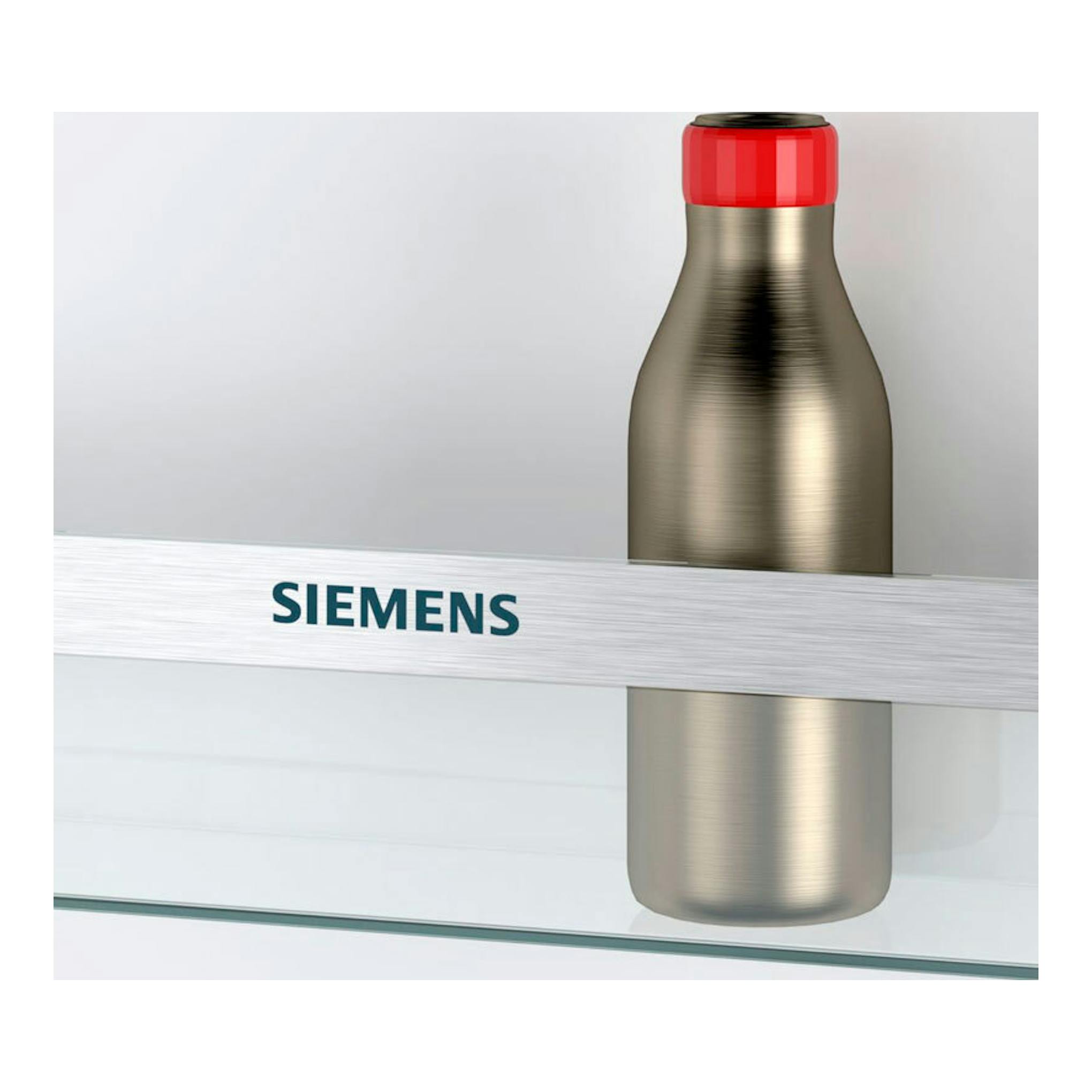 Detalle de frigorífico Siemens, con logotipo en barra metálica y botella metálica con tapa roja.