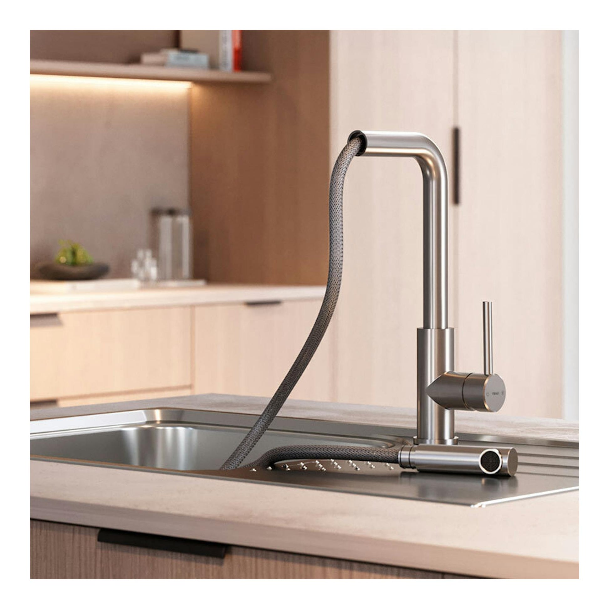 Grifo de cocina Teka UNI9331 en inox pulido, vista lateral en encimera con manguera extraíble.