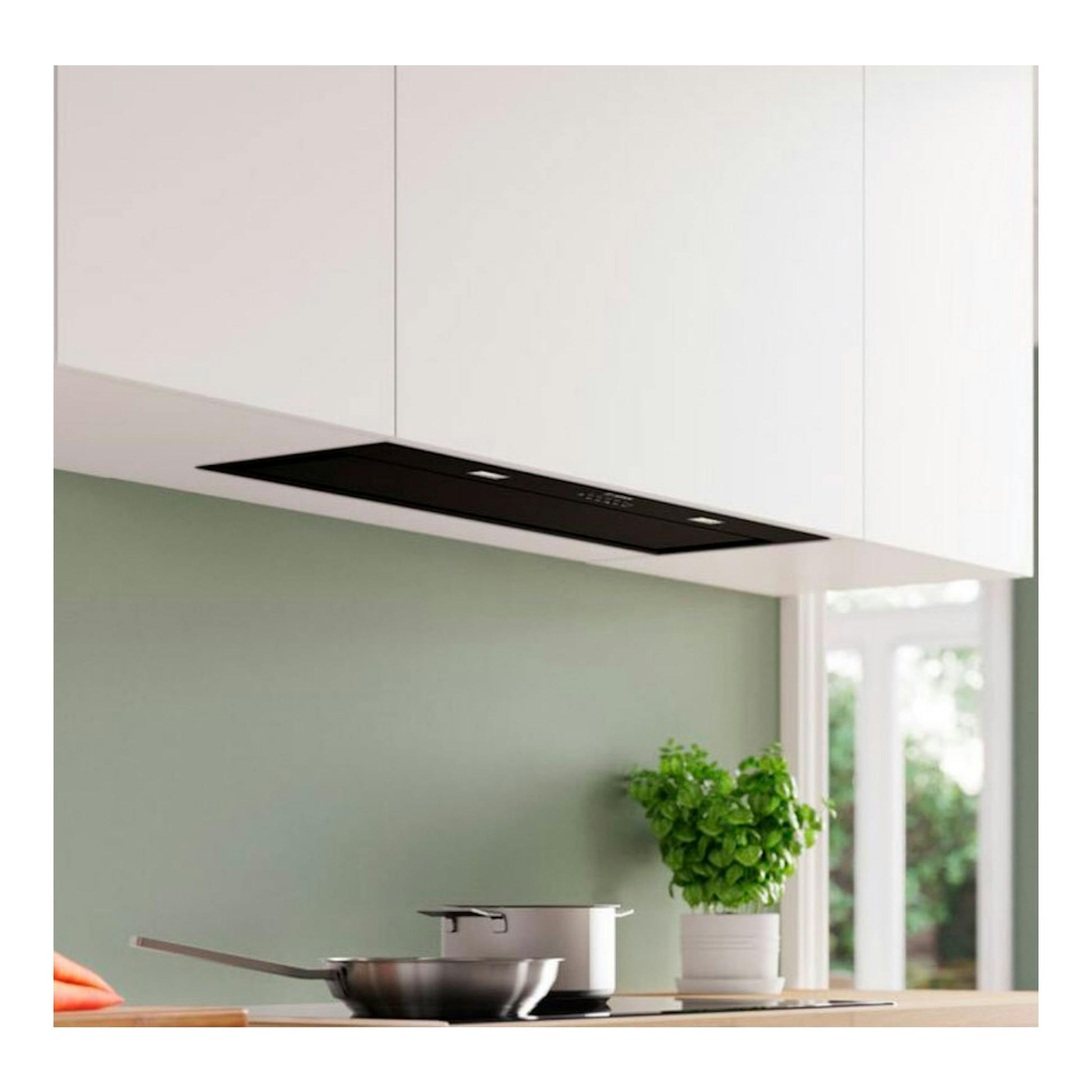 Grupo filtrante Bosch DLN88PC60 negro, integrado bajo mueble, vista frontal en cocina blanca.