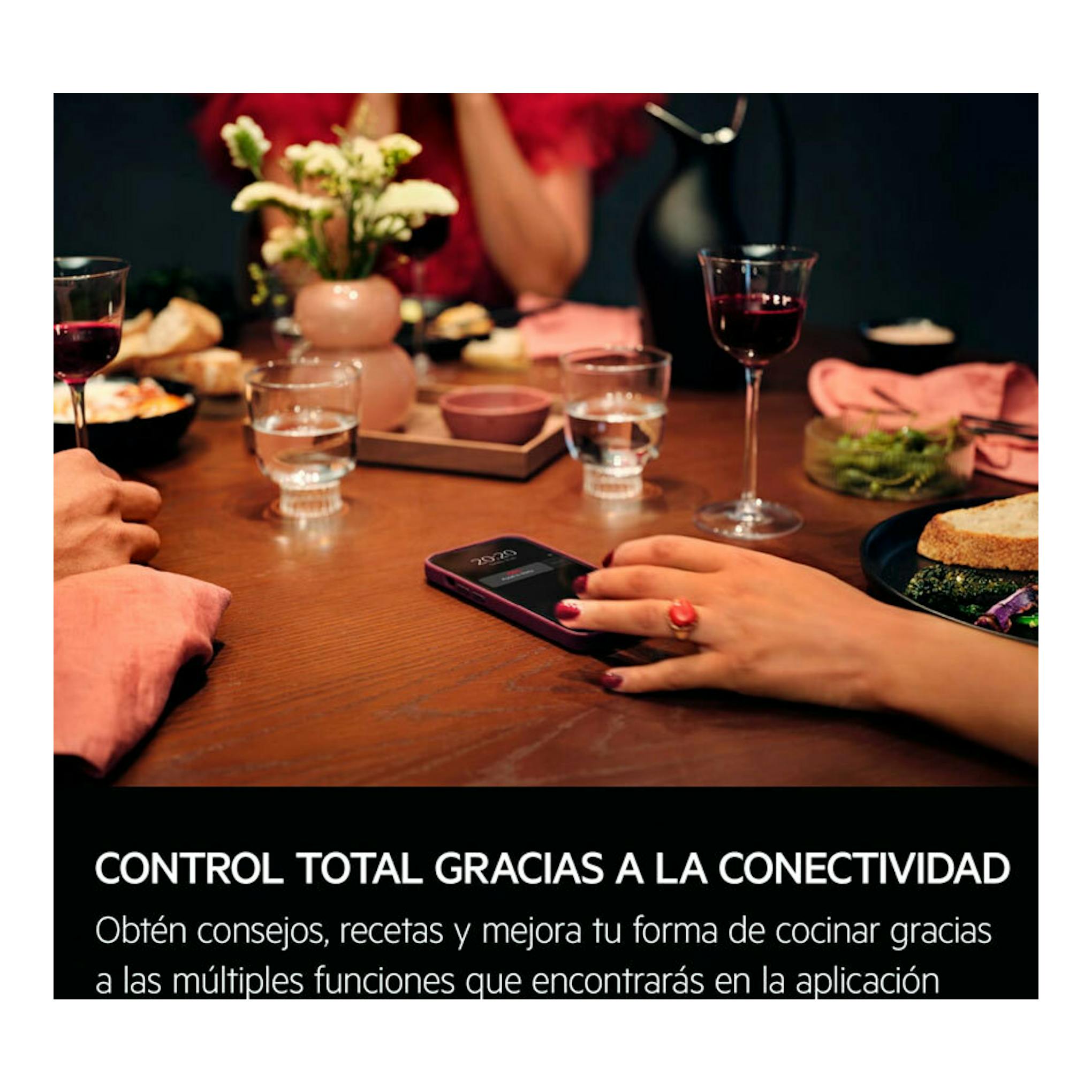 AEG OU5PB41WSB: móvil sobre mesa en una cena, con manos y copas; texto sobre conectividad en la parte inferior.