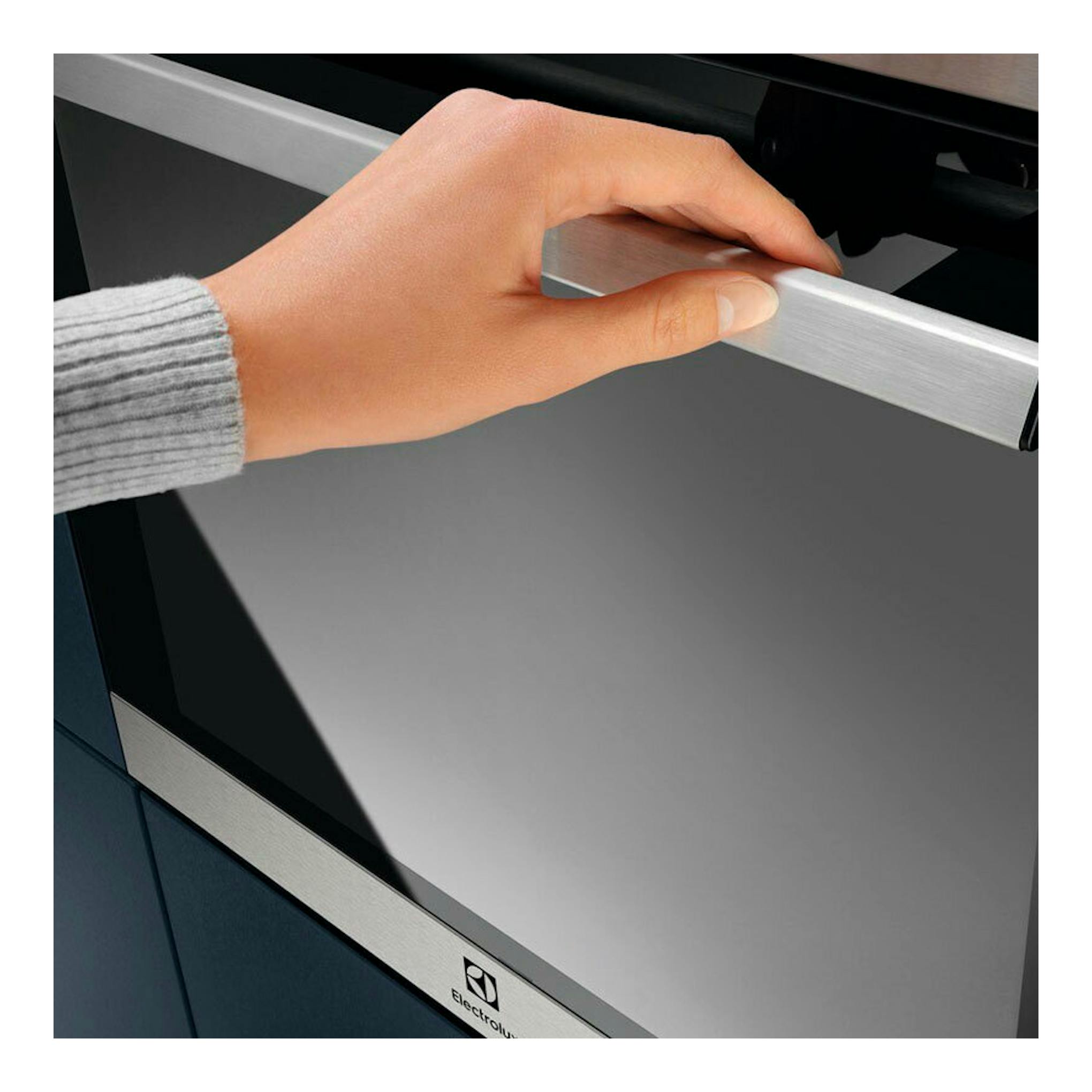 Horno Electrolux EOH4P56BX de acero inoxidable, vista frontal parcial, con una mano en la puerta.