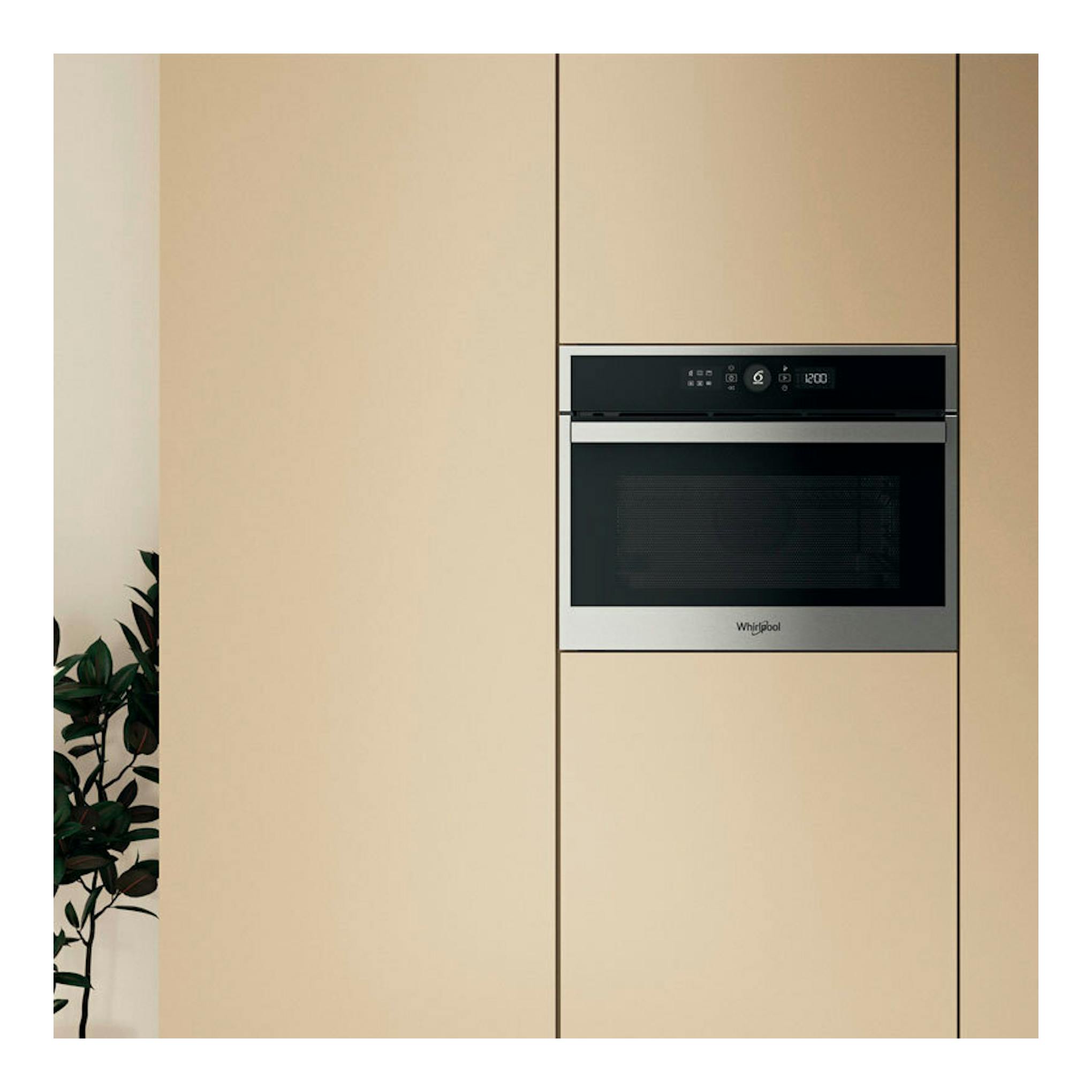 Horno empotrado Whirlpool WCC48HMSXA en inox, vista frontal, integrado en mueble beige.