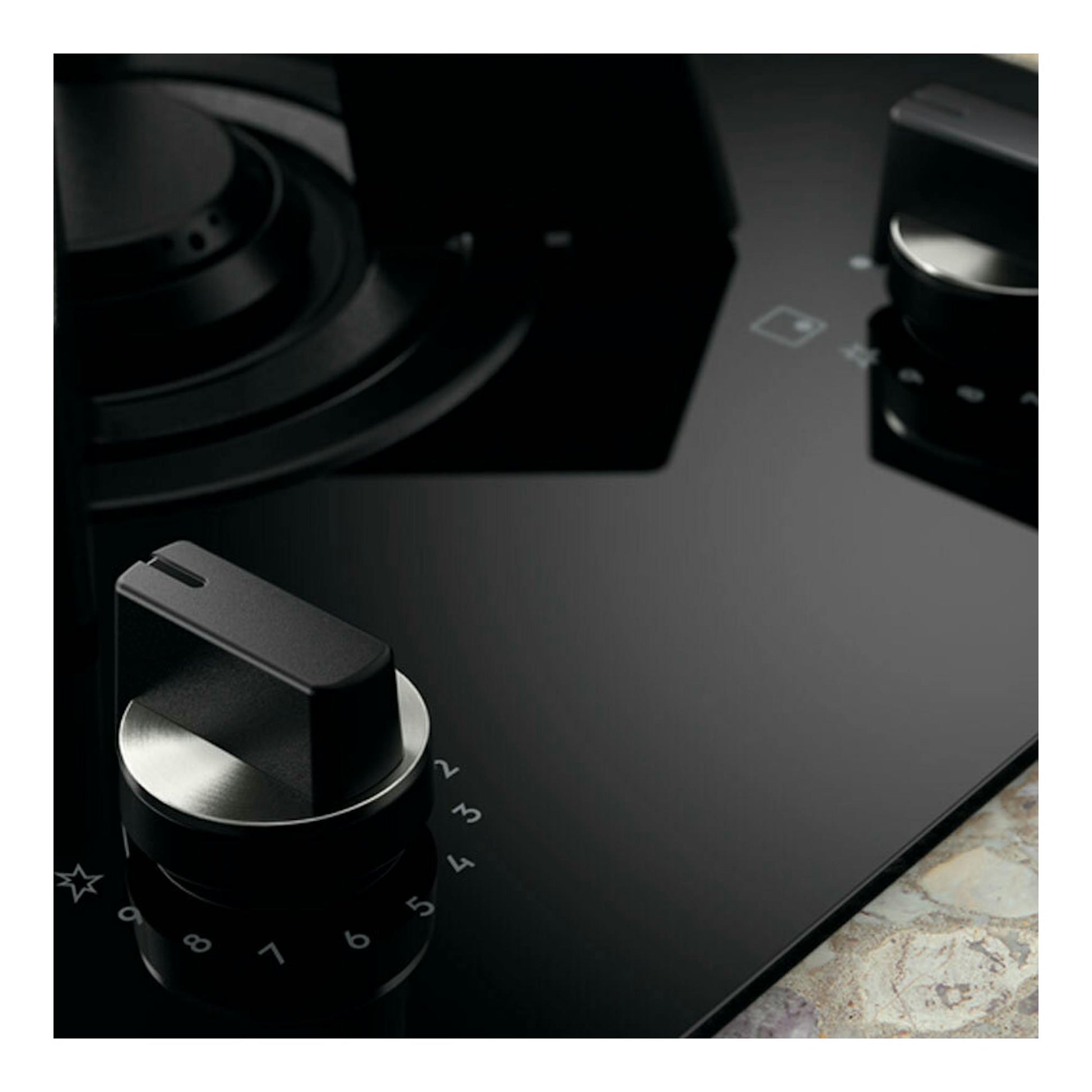 Placa de inducción Electrolux KDI641723K negra, vista en primer plano con mandos giratorios.