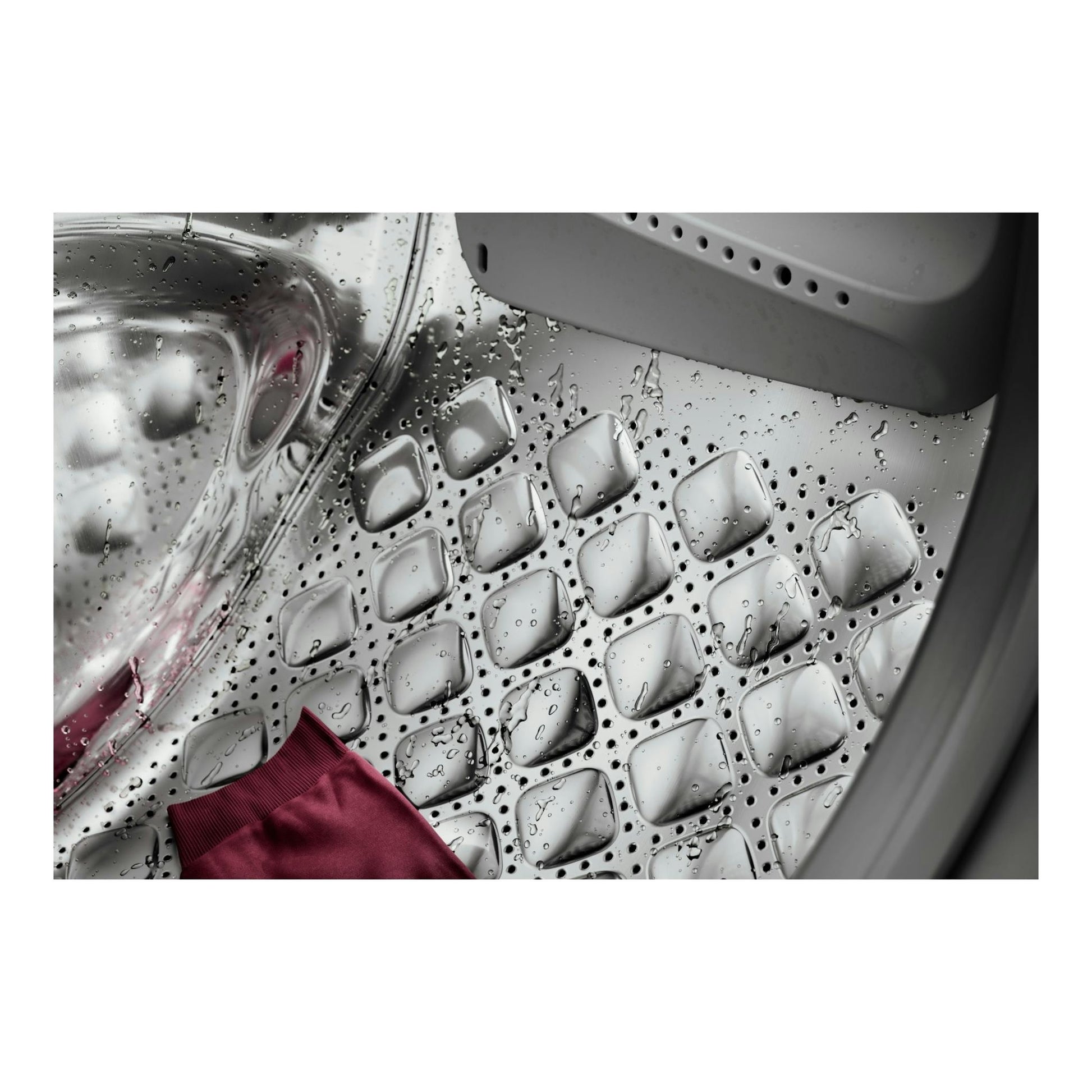 Interior de lavadora AEG LFR7394O4V, vista cenital del tambor de acero con gotas de agua y una prenda rosa.