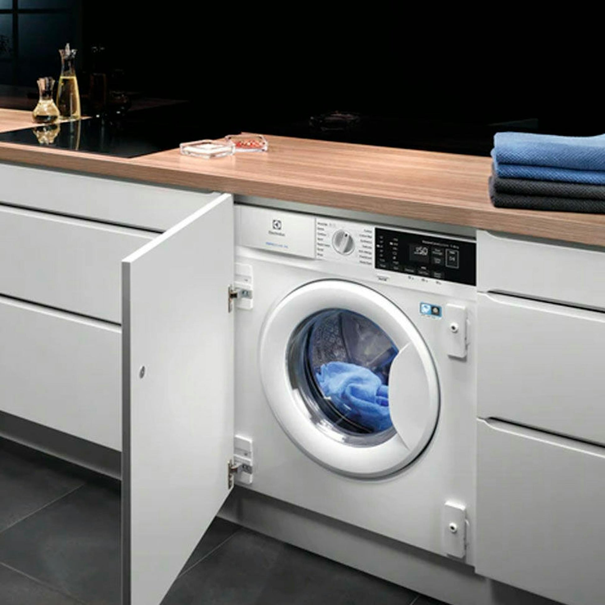 Lavadora integrable Electrolux EN7F4722AN 7Kg empotrada en cocina con la puerta abierta