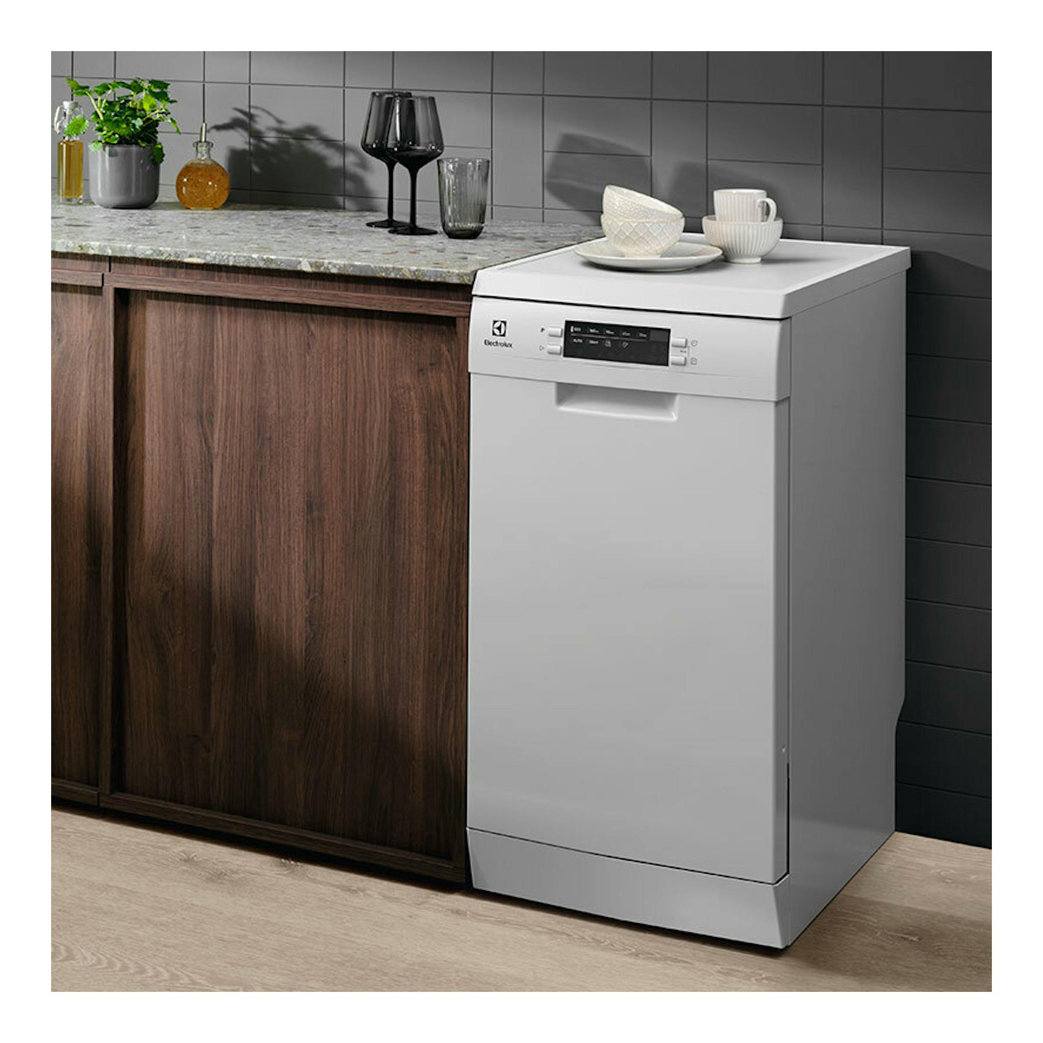 Lavavajillas Electrolux ESS42220SW blanco, vista frontal en cocina, junto a encimera de madera.