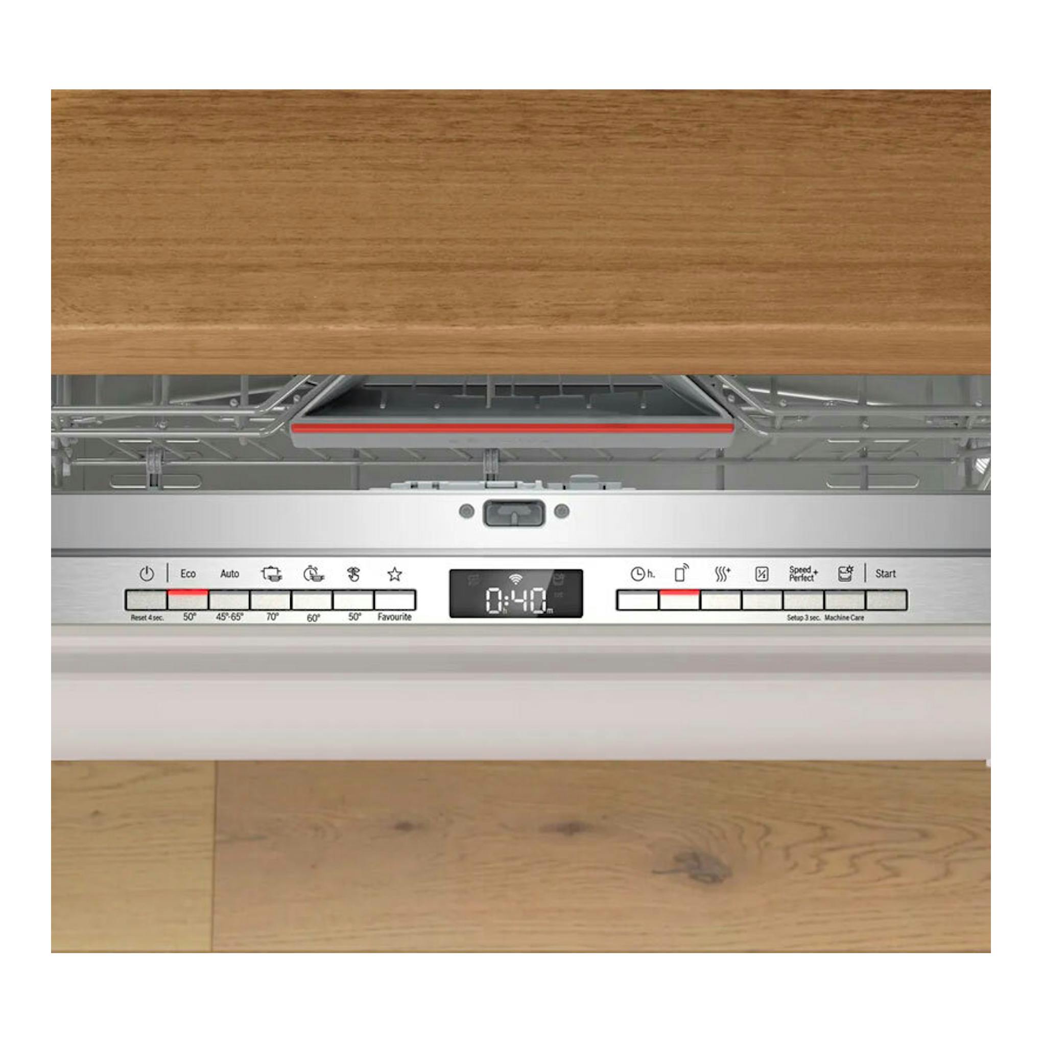 Lavavajillas integrable Bosch SMH4ECX28E, panel frontal blanco y control digital bajo frente de madera.
