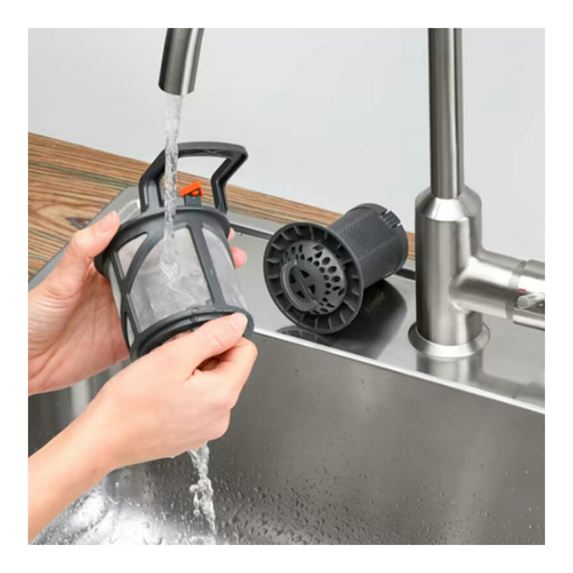 Filtro de lavavajillas Electrolux EEG68500L siendo aclarado bajo un grifo, vista cenital parcial.