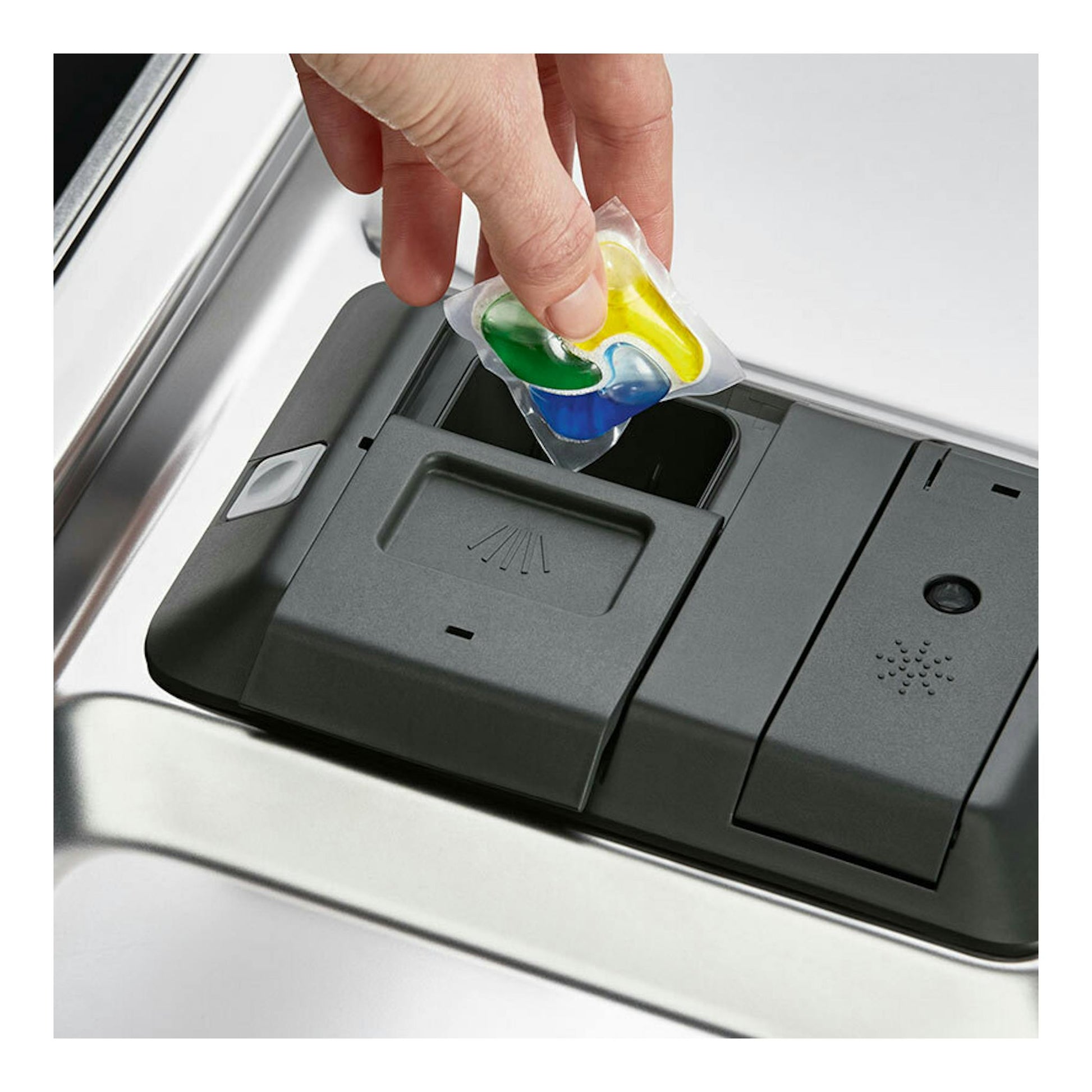 Electrolux EES47400L: primer plano del dispensador de un lavavajillas integrable negro con una mano colocando una pastilla.