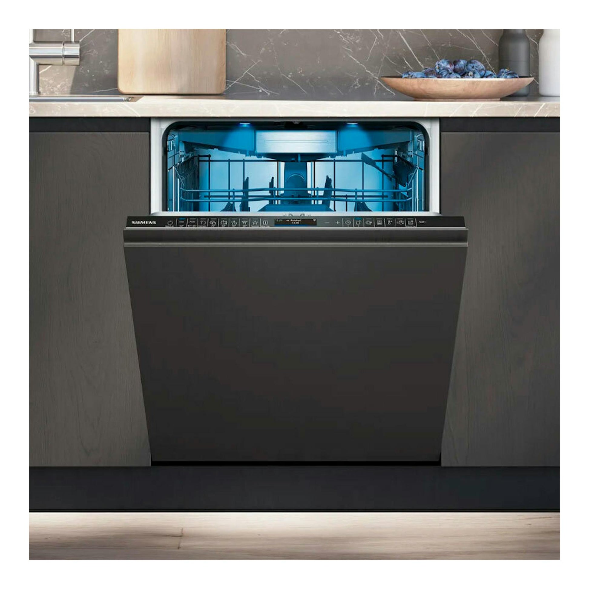 Vista frontal de lavavajillas integrable Siemens SX87TX02CE abierto, con interior iluminado en azul bajo encimera.