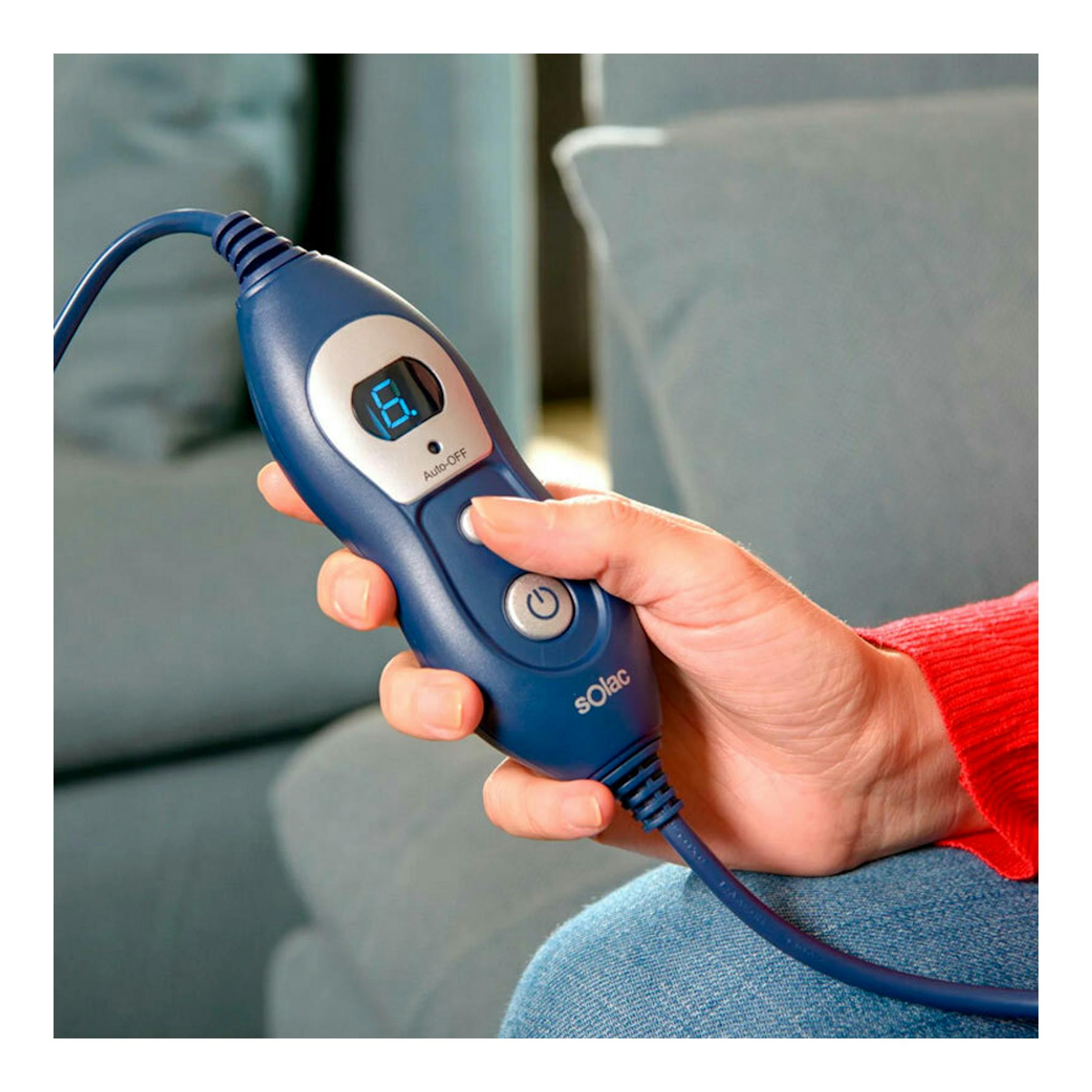 Mando azul de la manta Solac CT8607 Reikiavik Single, vista frontal, en mano, con pantalla digital.