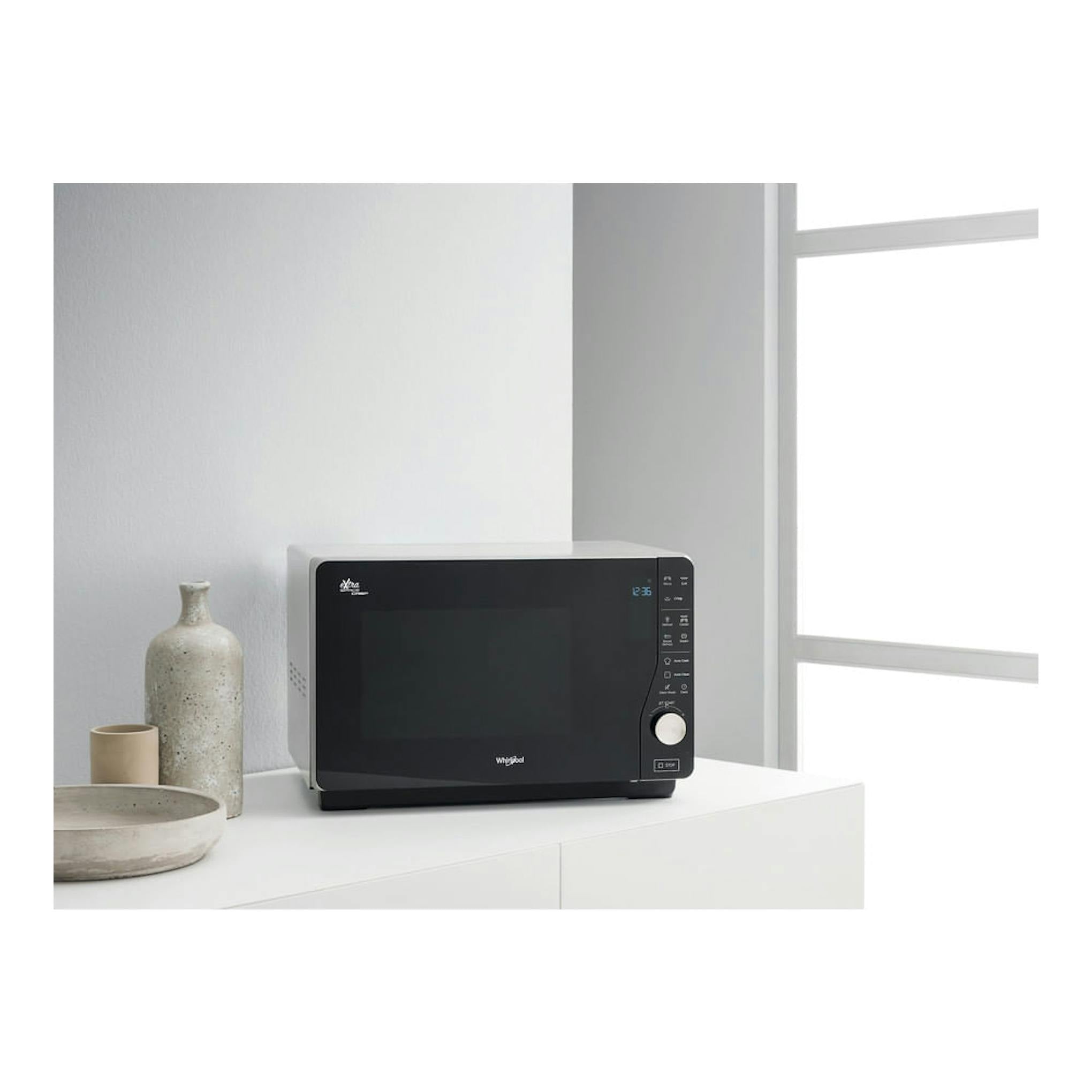 Microondas Whirlpool MWF 427 SL negro, vista frontal en encimera blanca, con panel de control lateral.