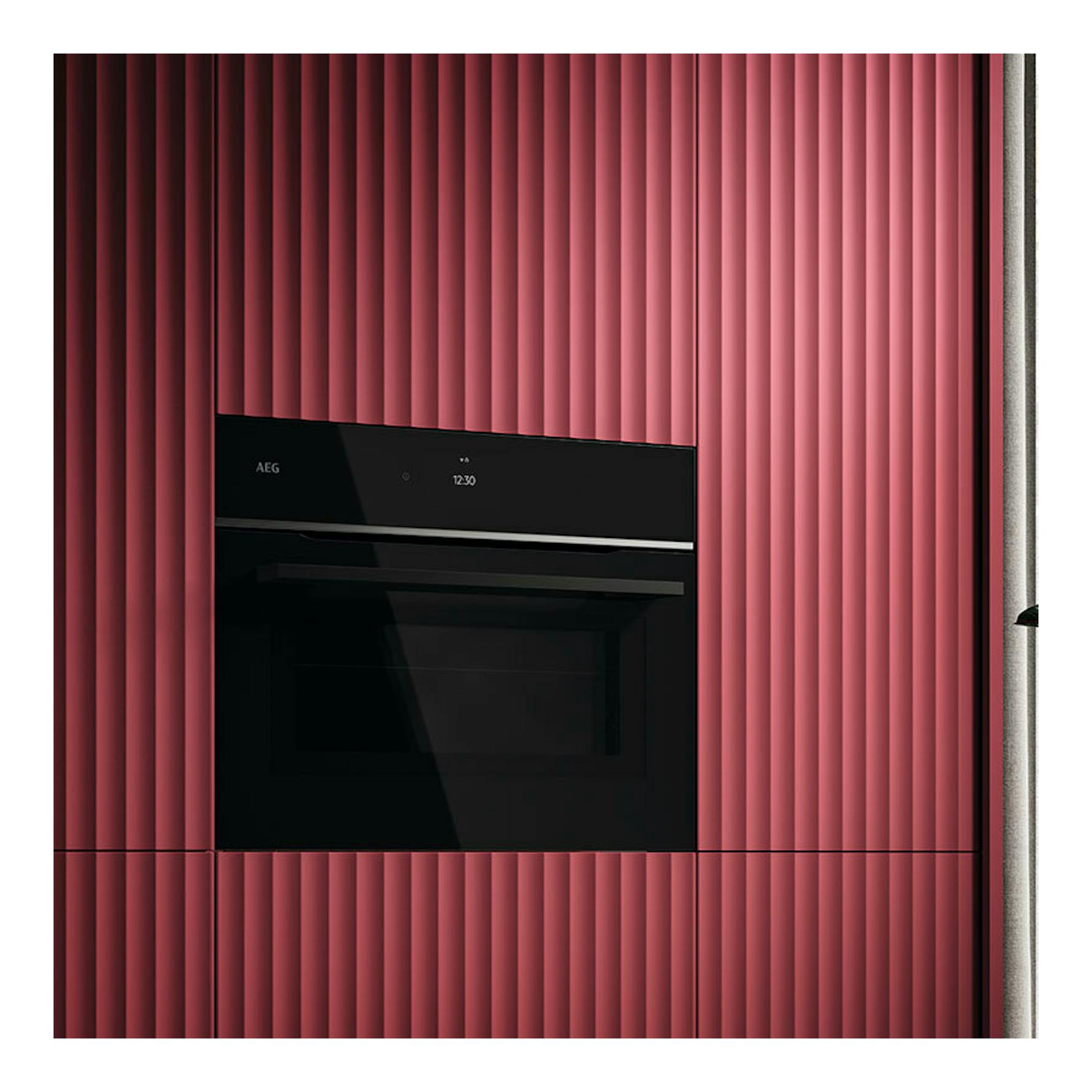 Microondas integrable AEG TM7NK721B negro, vista frontal empotrada en mueble rosa.