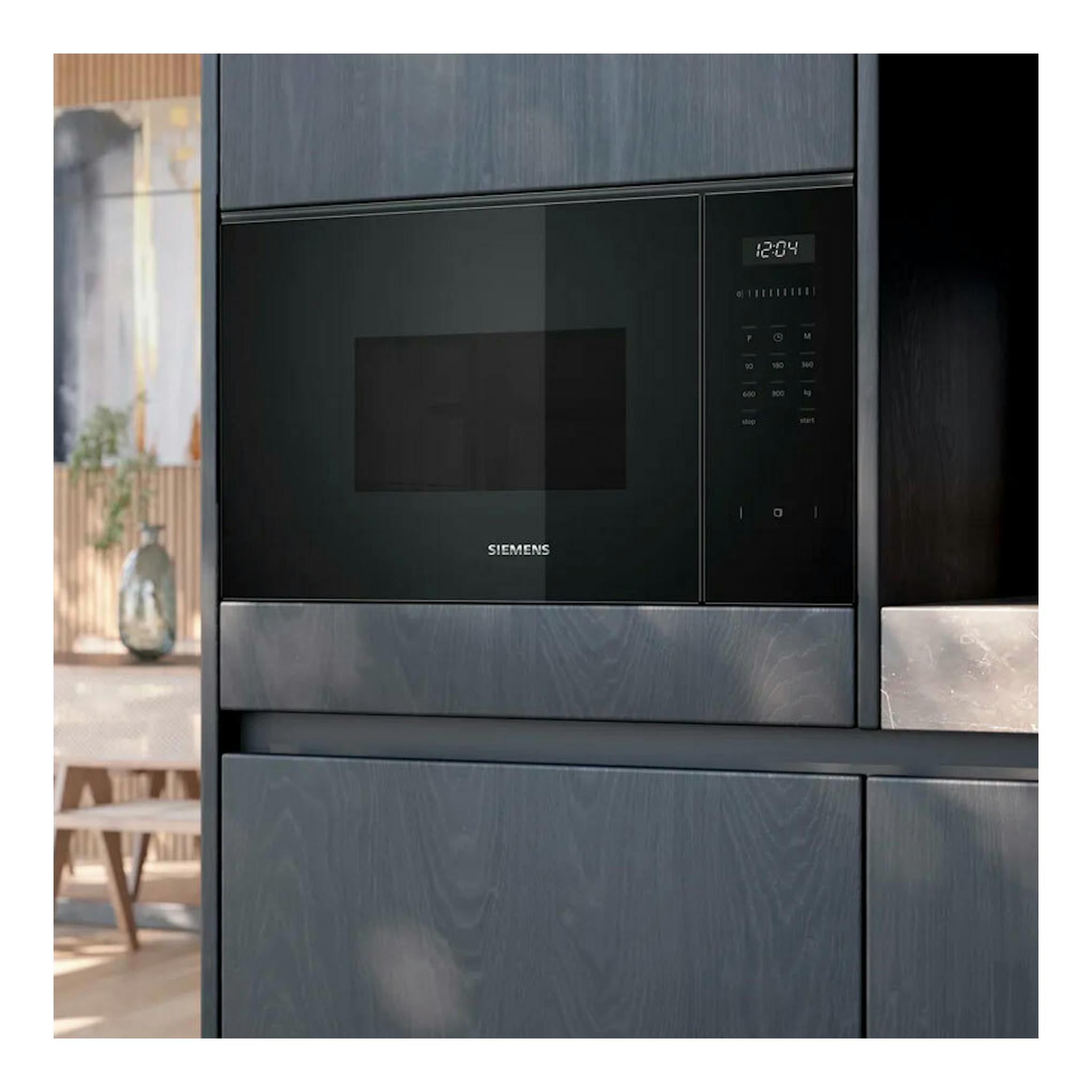Microondas integrable Siemens BF525LMB1 de cristal negro, vista frontal empotrada en mueble de cocina.