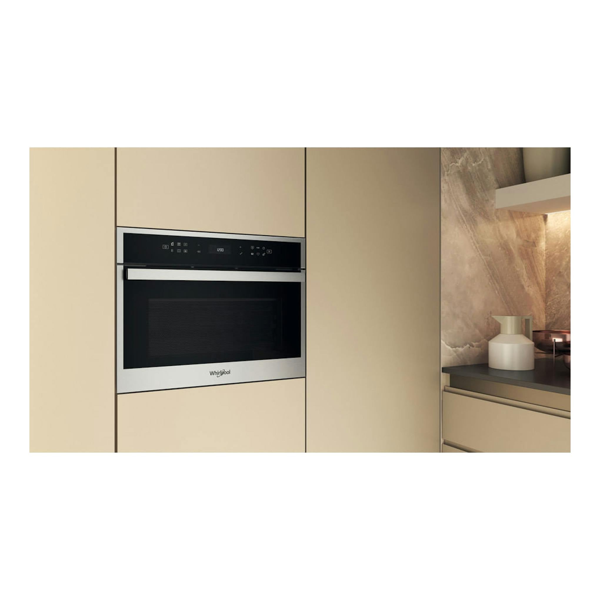Microondas integrable Whirlpool WCW607HTSX en inox, empotrado en mueble beige, vista frontal.