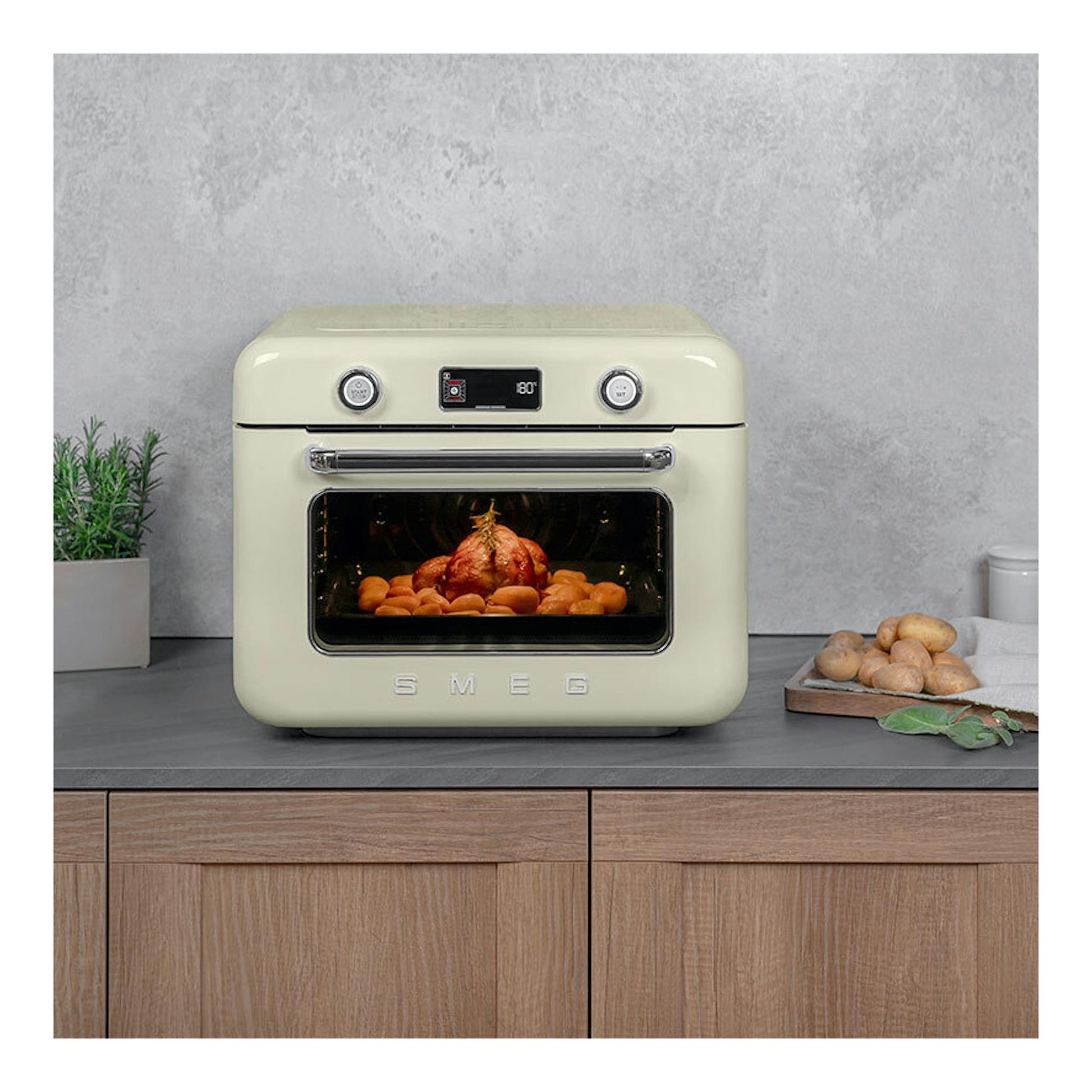 Minihorno Smeg COF01CREU crema, vista frontal, con comida cocinándose en el interior.