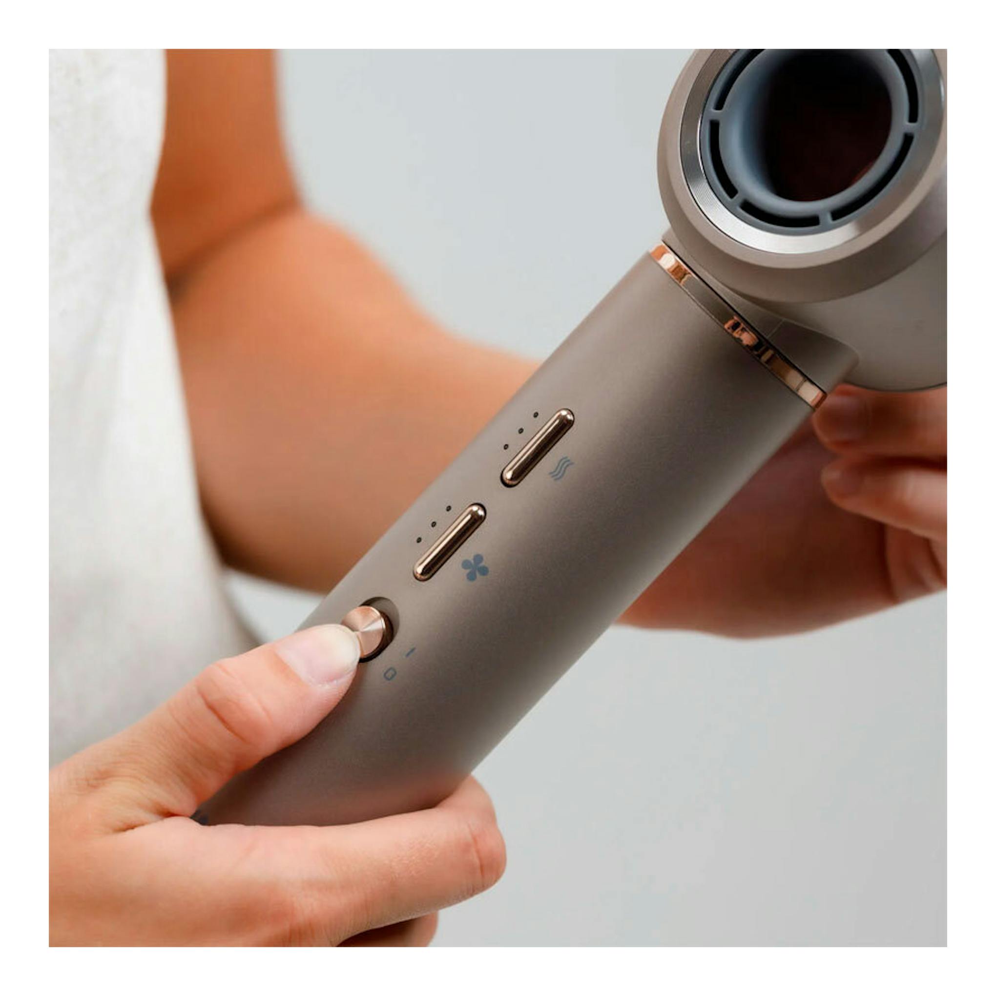 Moldeador de pelo Taurus Airwave Digital Pro gris con detalles rosé, en primer plano y vista lateral, sostenido con la mano.