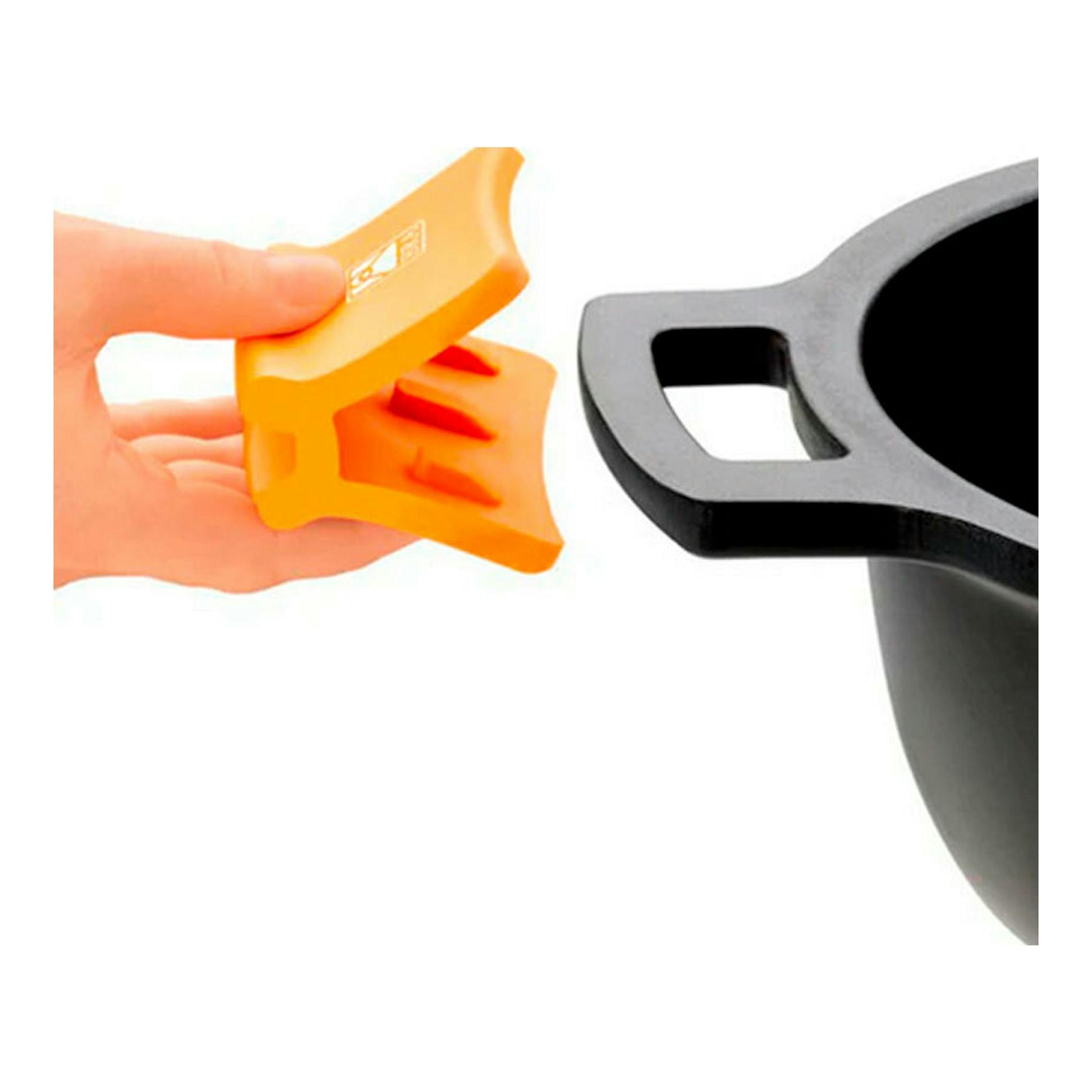 Primer plano de paellera Bra Efficient negra con asa y mano colocando un protector de silicona naranja.