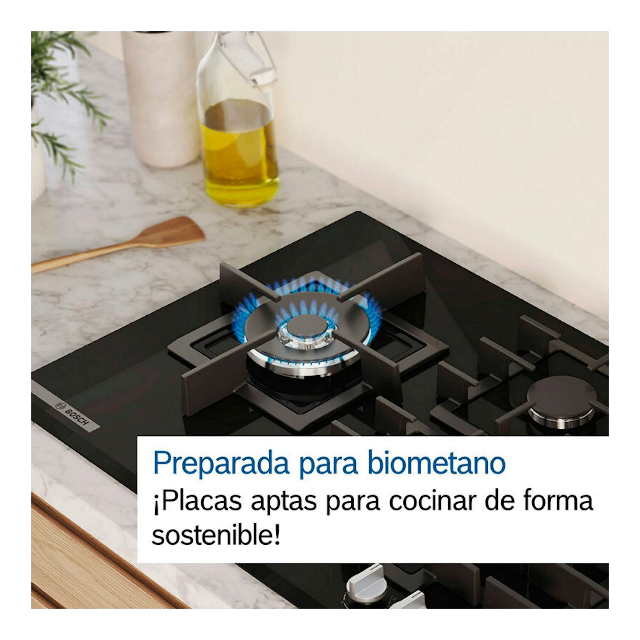 Placa de gas Bosch PGC6B5K90 negra, vista en ángulo sobre encimera de mármol, con un quemador encendido.