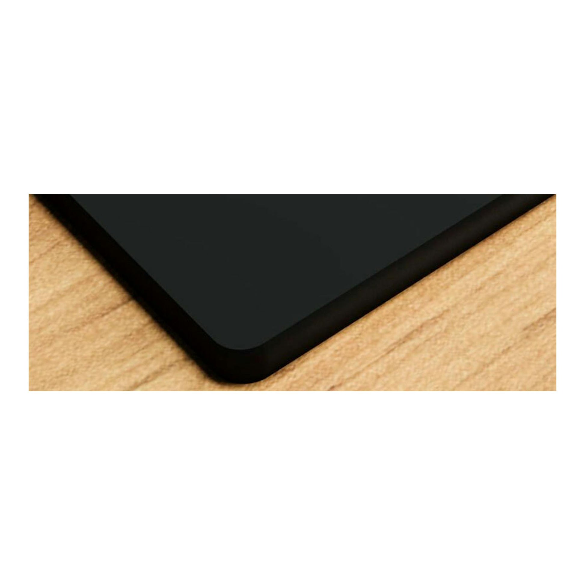 Placa de cristal Bosch PPC6A6I10 negra, vista en primer plano de una esquina sobre superficie de madera.