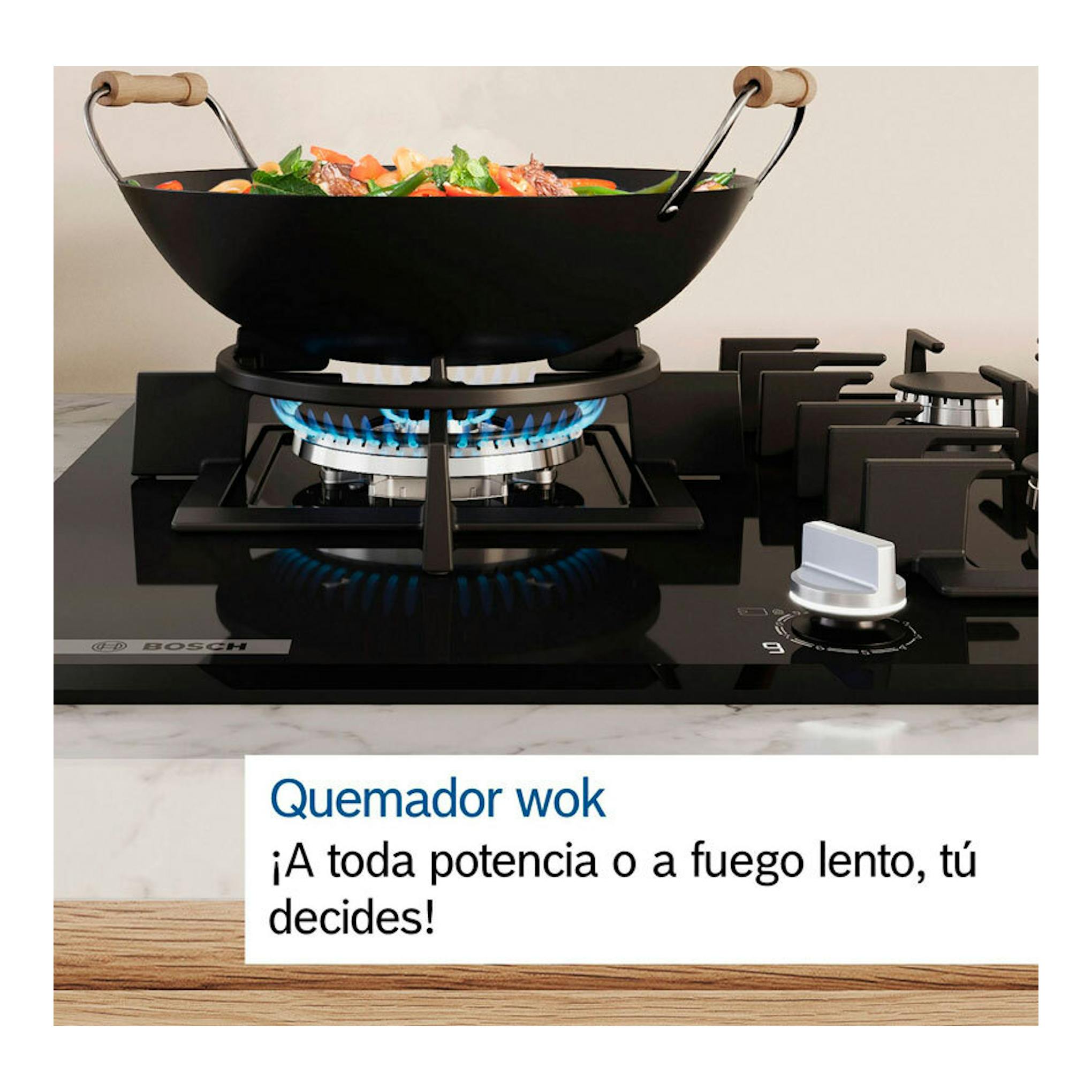 Placa de gas Bosch PPC6A6I10 negra de cristal, vista frontal, con sartén wok sobre quemador encendido.