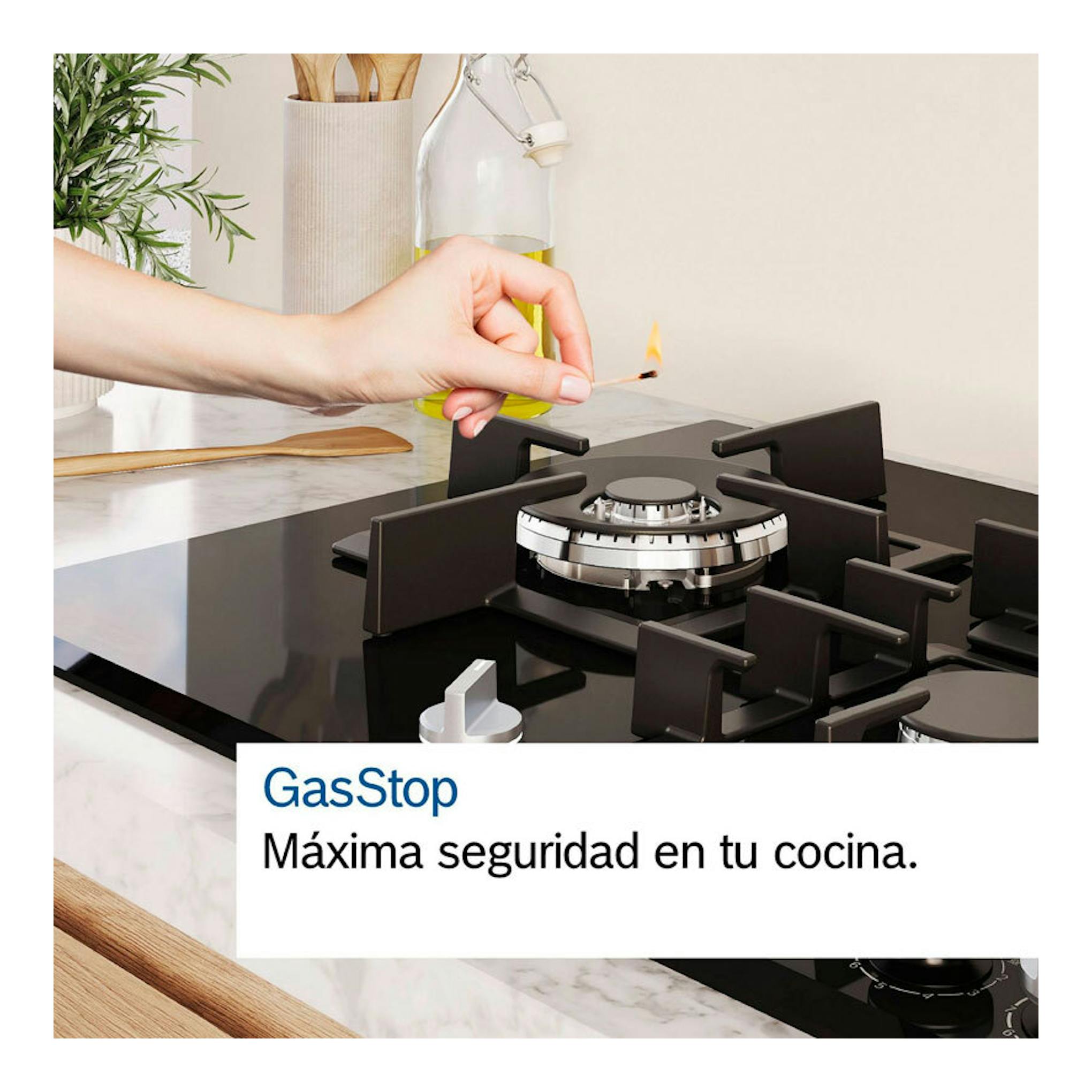 Bosch PRB3A6I40: placa de gas de cristal negra con un quemador encendido y una mano usando un fósforo.
