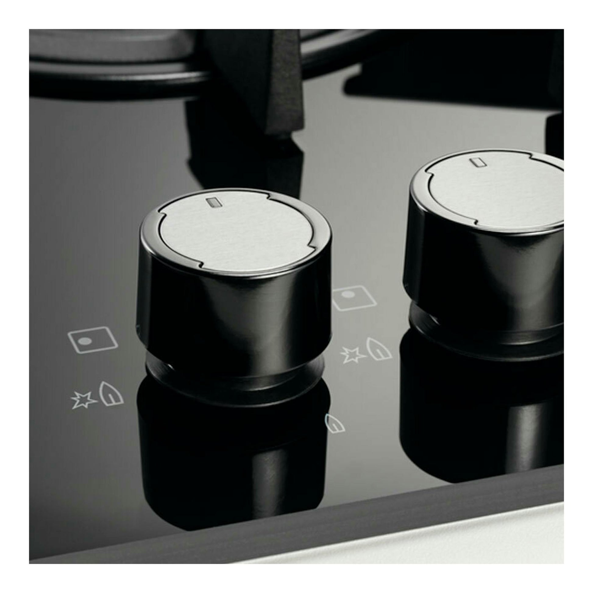 Placa de cristal negra Electrolux KGE6633NOK, vista en primer plano, con dos mandos metálicos.