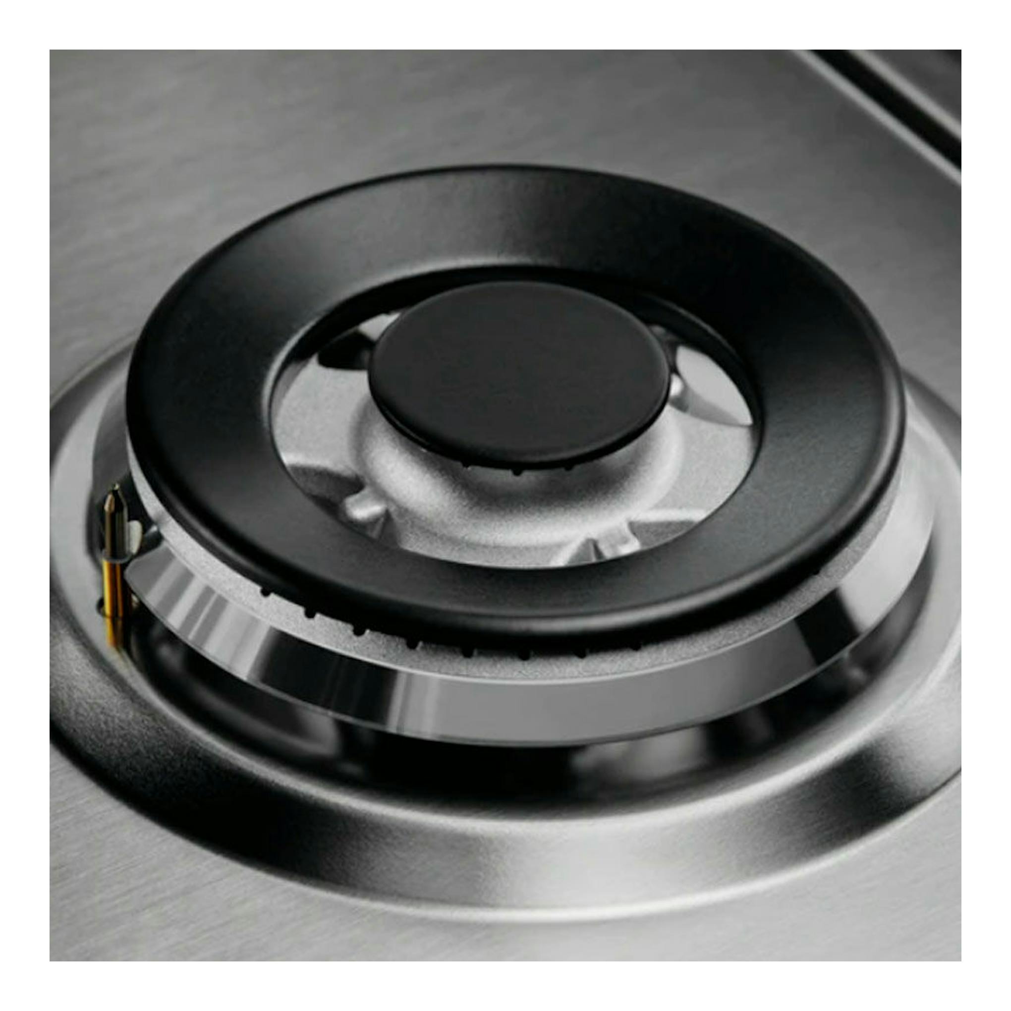 Placa de gas Electrolux KGS7536SX, primer plano de un quemador negro sobre superficie de acero inoxidable.