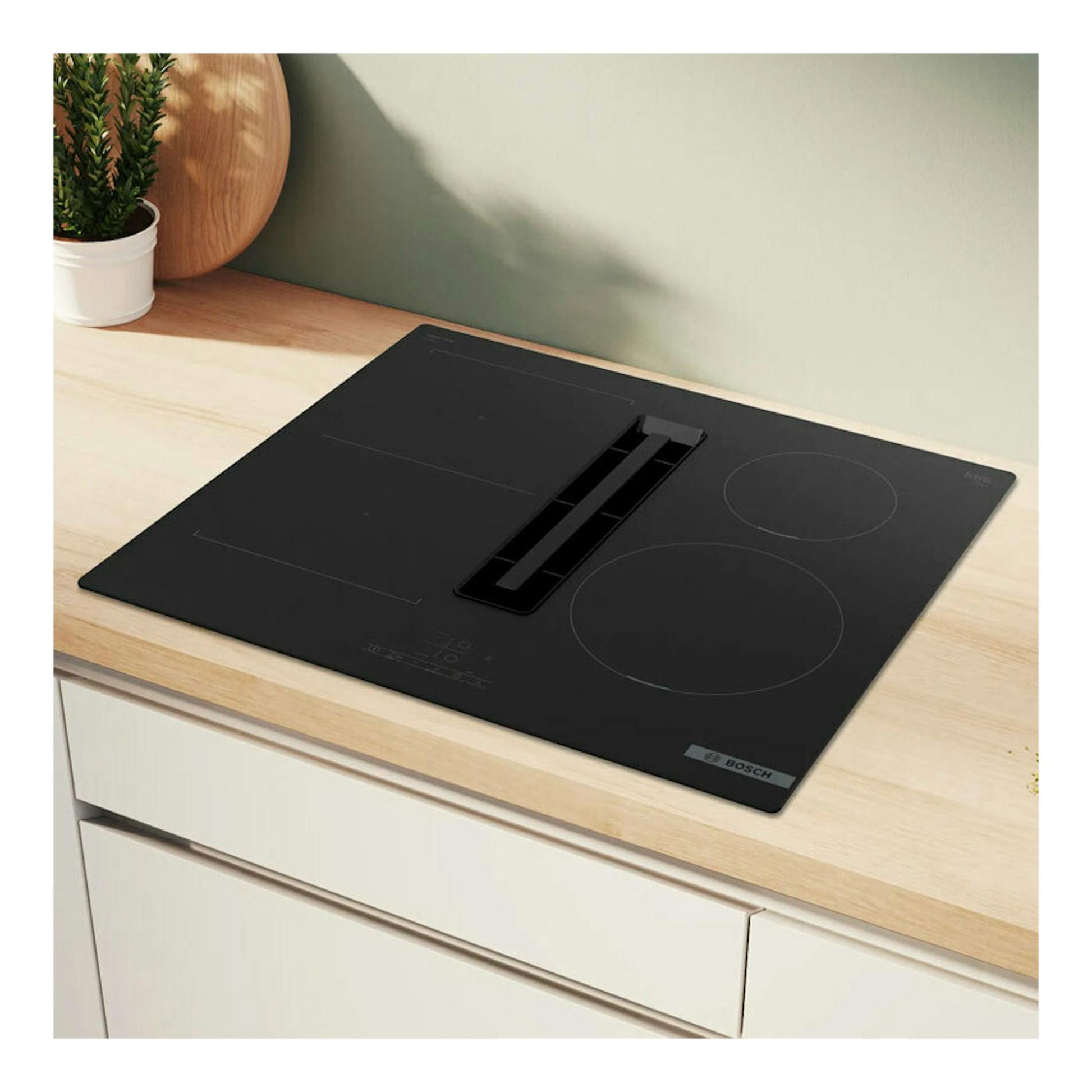 Placa de inducción Bosch PVS611B16E negra con extractor integrado, vista superior sobre encimera de madera.