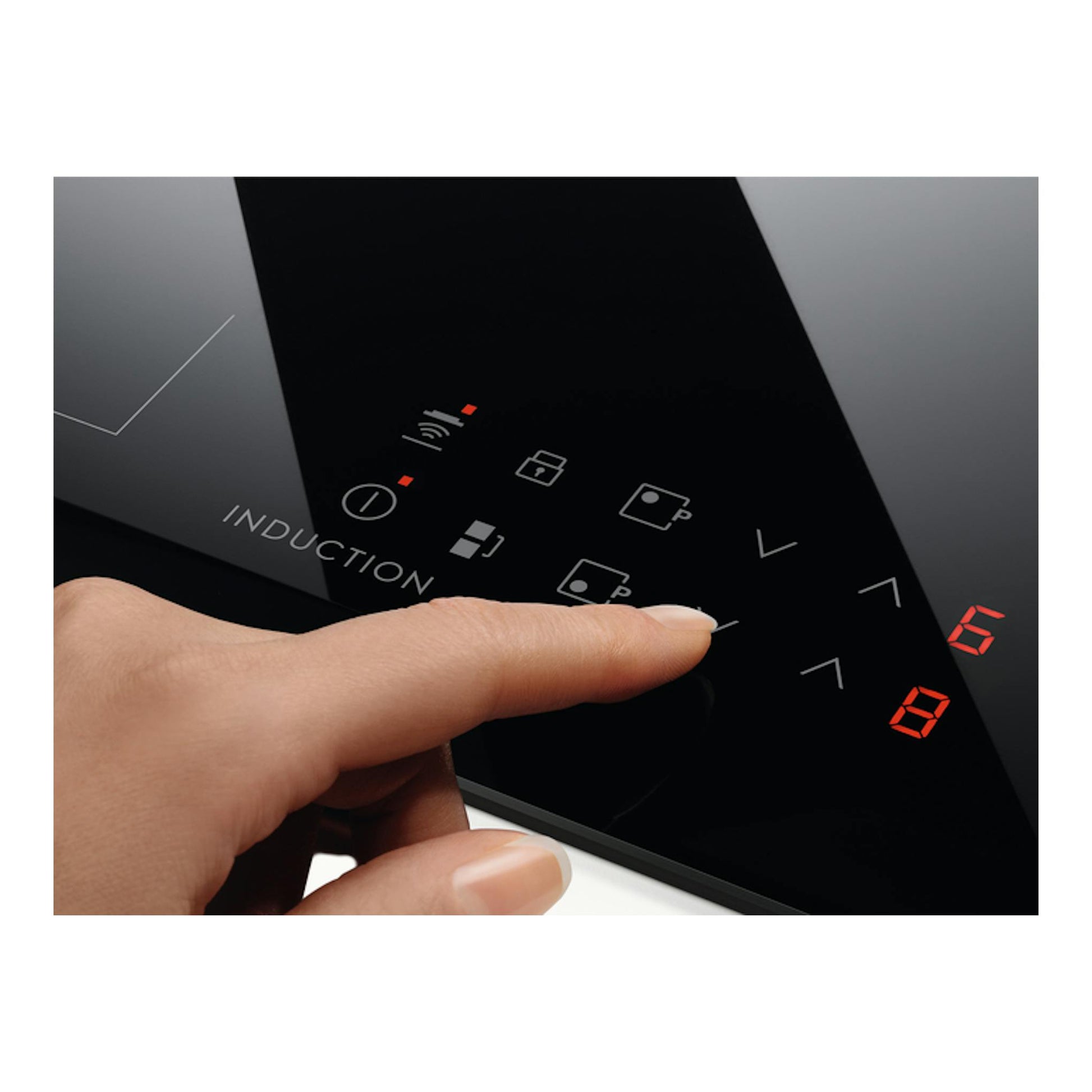 Placa de inducción Electrolux EIT61336CB negra en primer plano, con un dedo pulsando los controles táctiles.