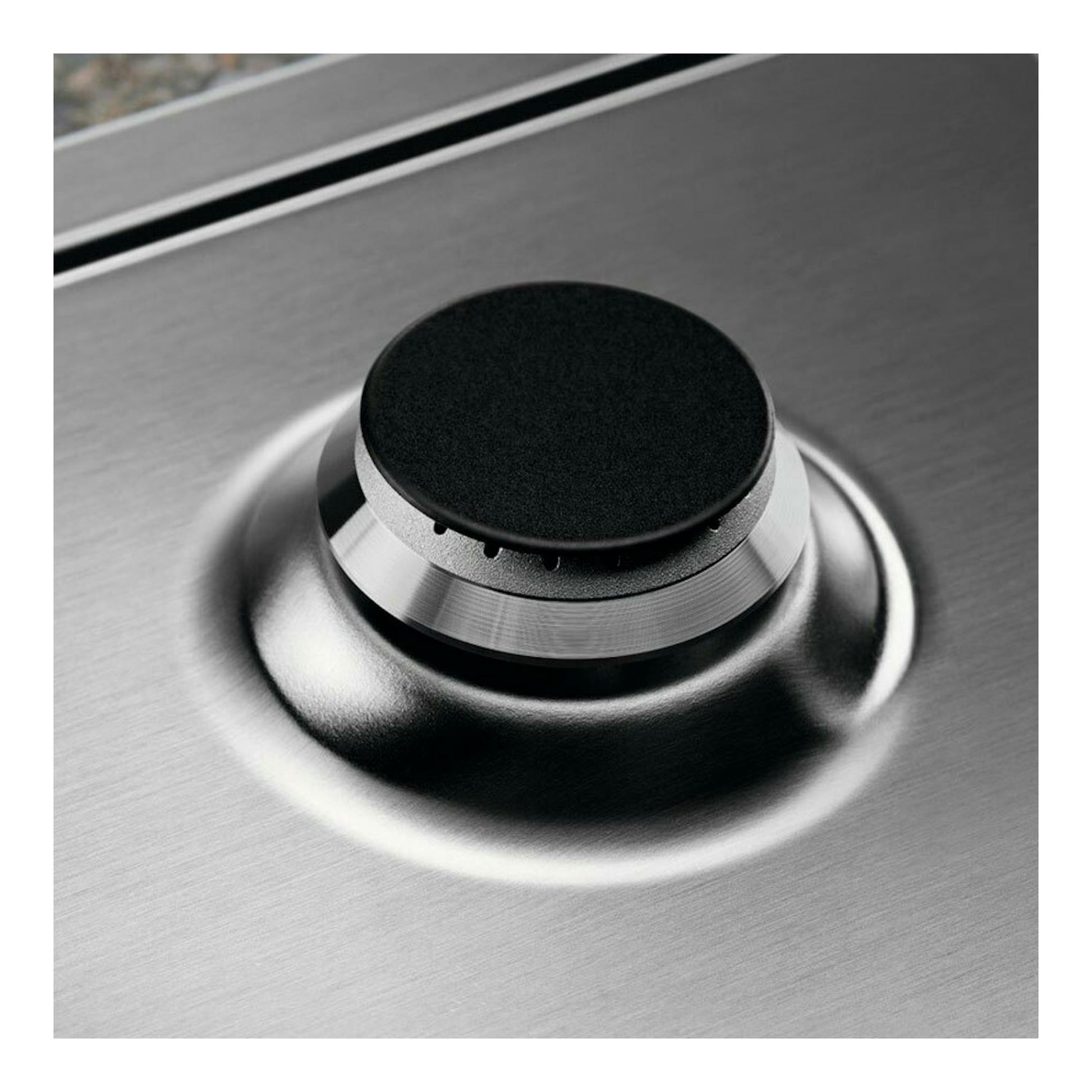 Placa de gas Electrolux KGS6436SX, vista en primer plano de un quemador sobre acero inoxidable.