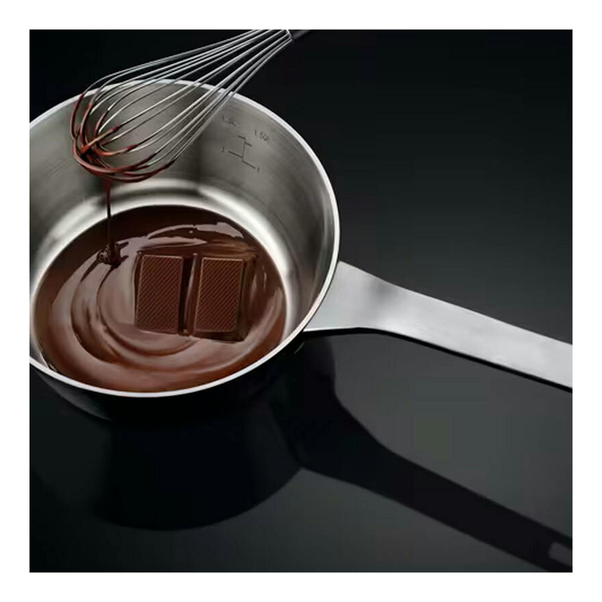 Placa de inducción AEG TI63IQ30FB negra, vista cenital, con cazo de acero, chocolate y batidor.