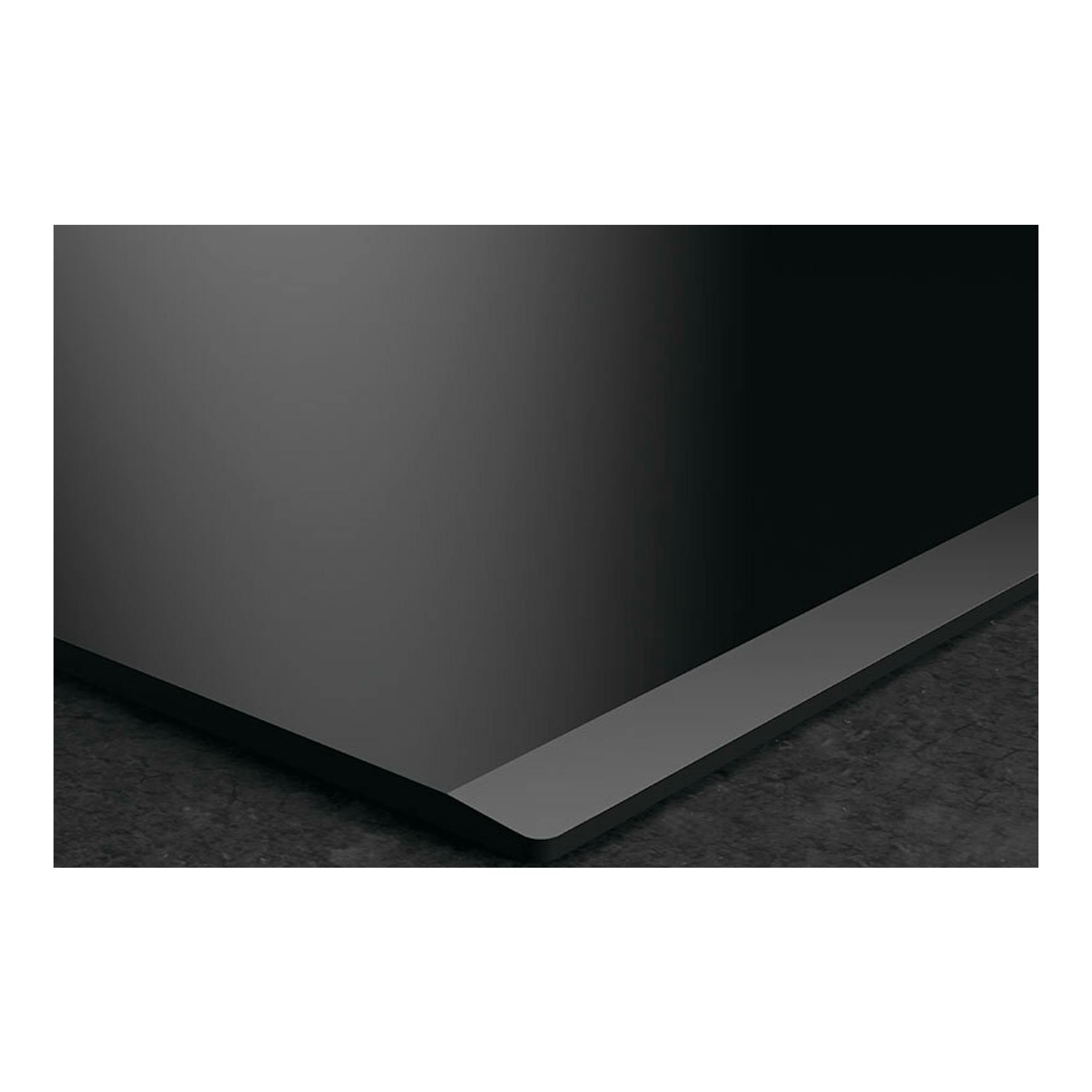 Placa de inducción AEG TN63IA00FB negra, vista en primer plano de una esquina sobre encimera oscura.