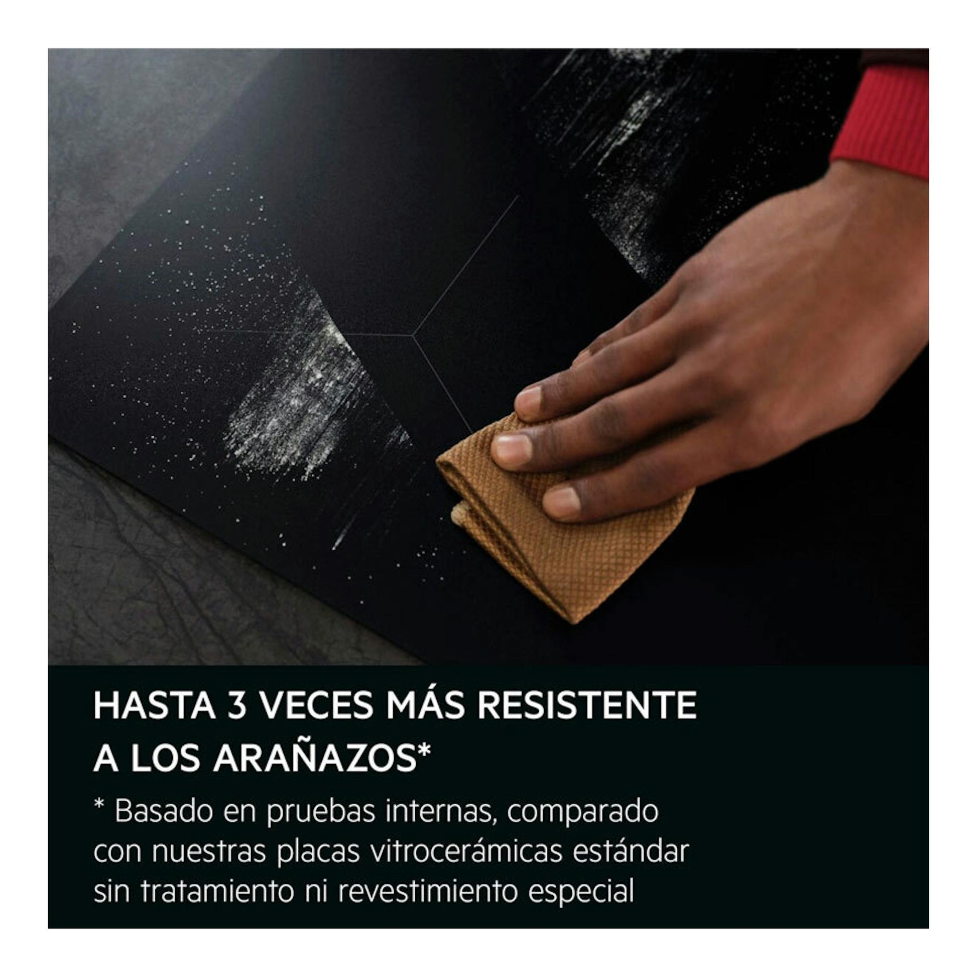 Placa de inducción AEG TN63IV00CB negra, vista superior, limpiándose con un paño y una mano.