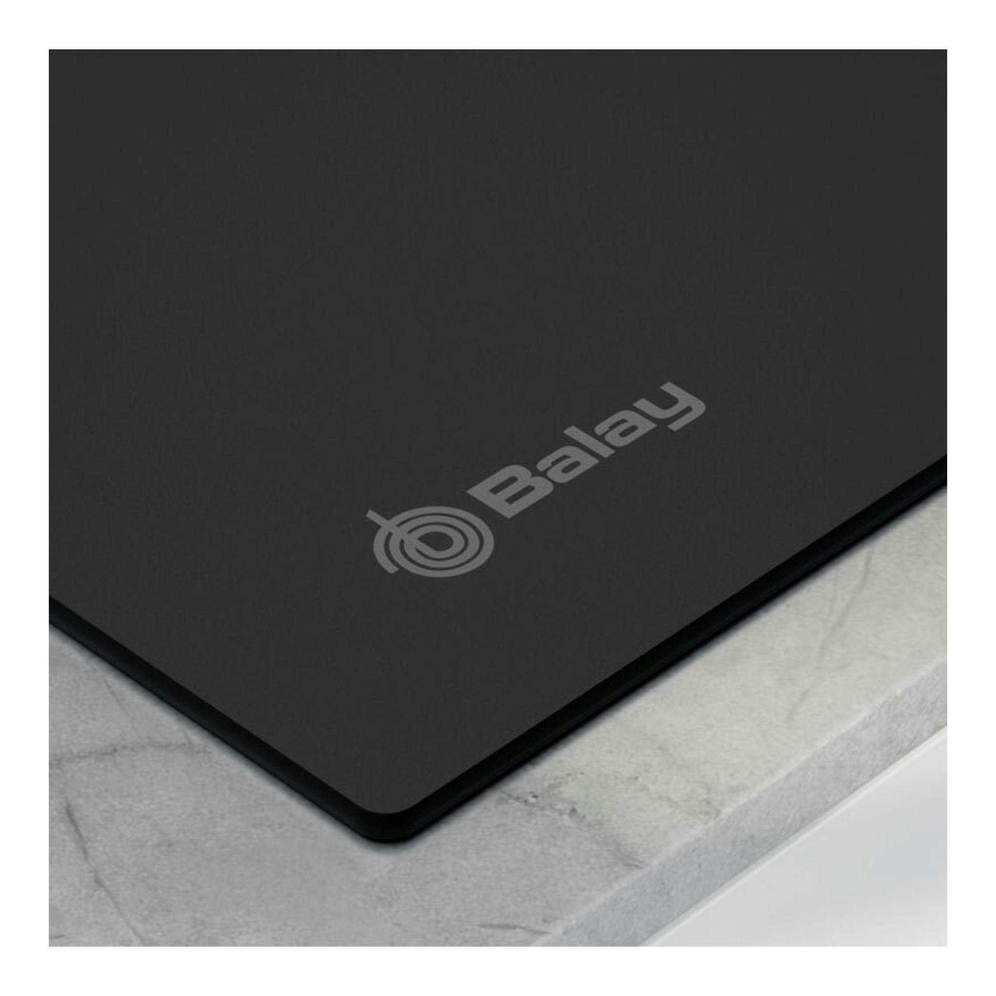 Placa de inducción Balay 3EB965MH negra, vista en ángulo, con logotipo en la superficie.