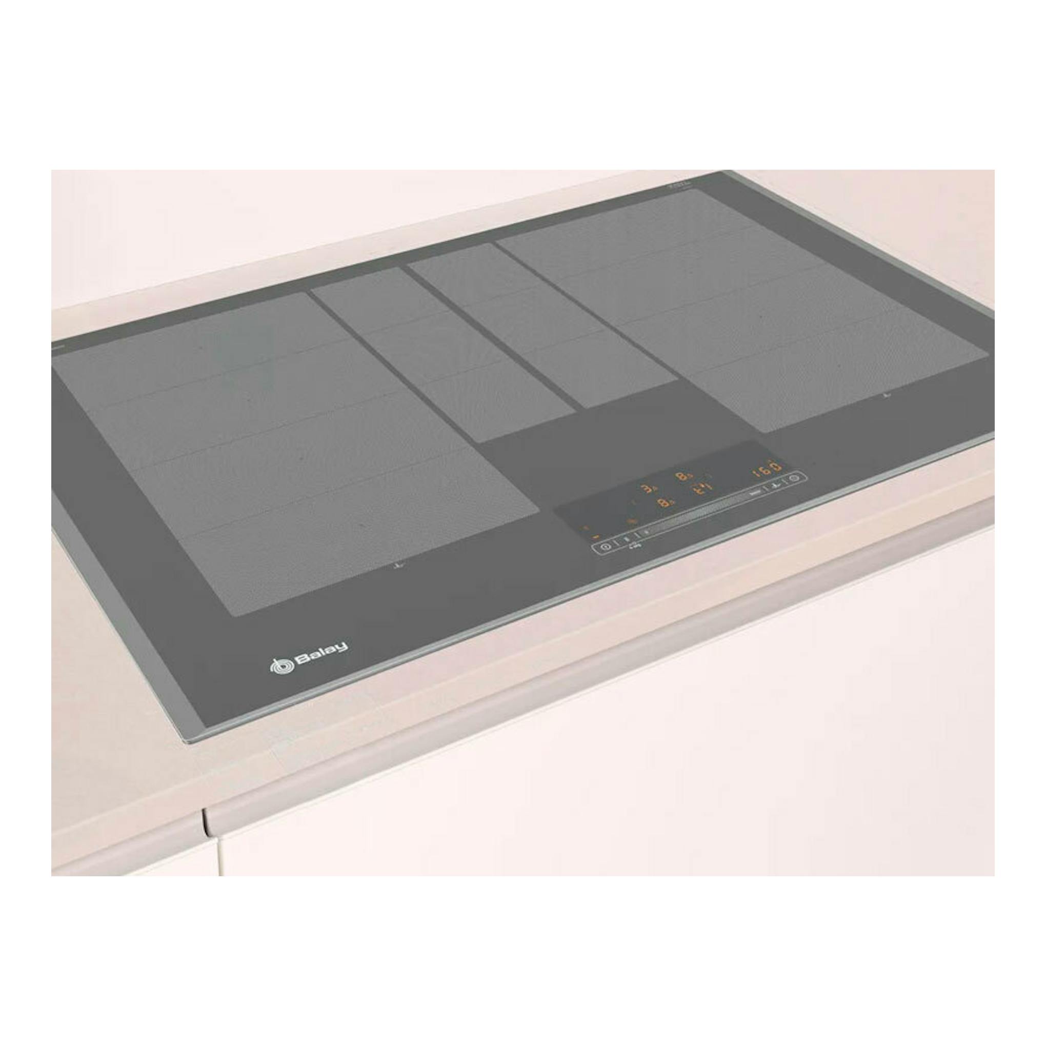 Placa de inducción Balay 3EB980AH negra, vista en ángulo sobre encimera blanca.