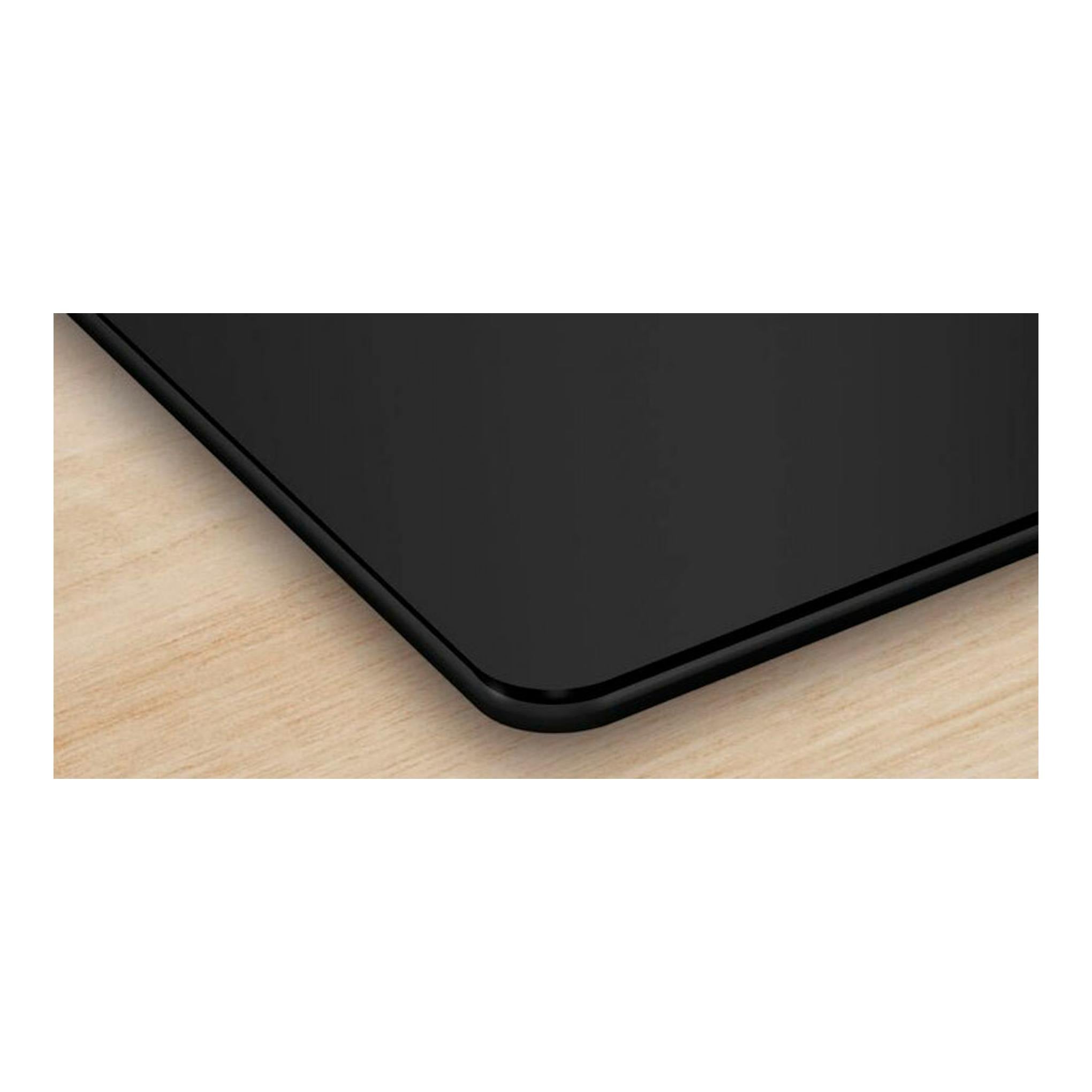 Placa de inducción Bosch PIE611BB5E negra, vista en detalle de la esquina sobre encimera de madera clara.
