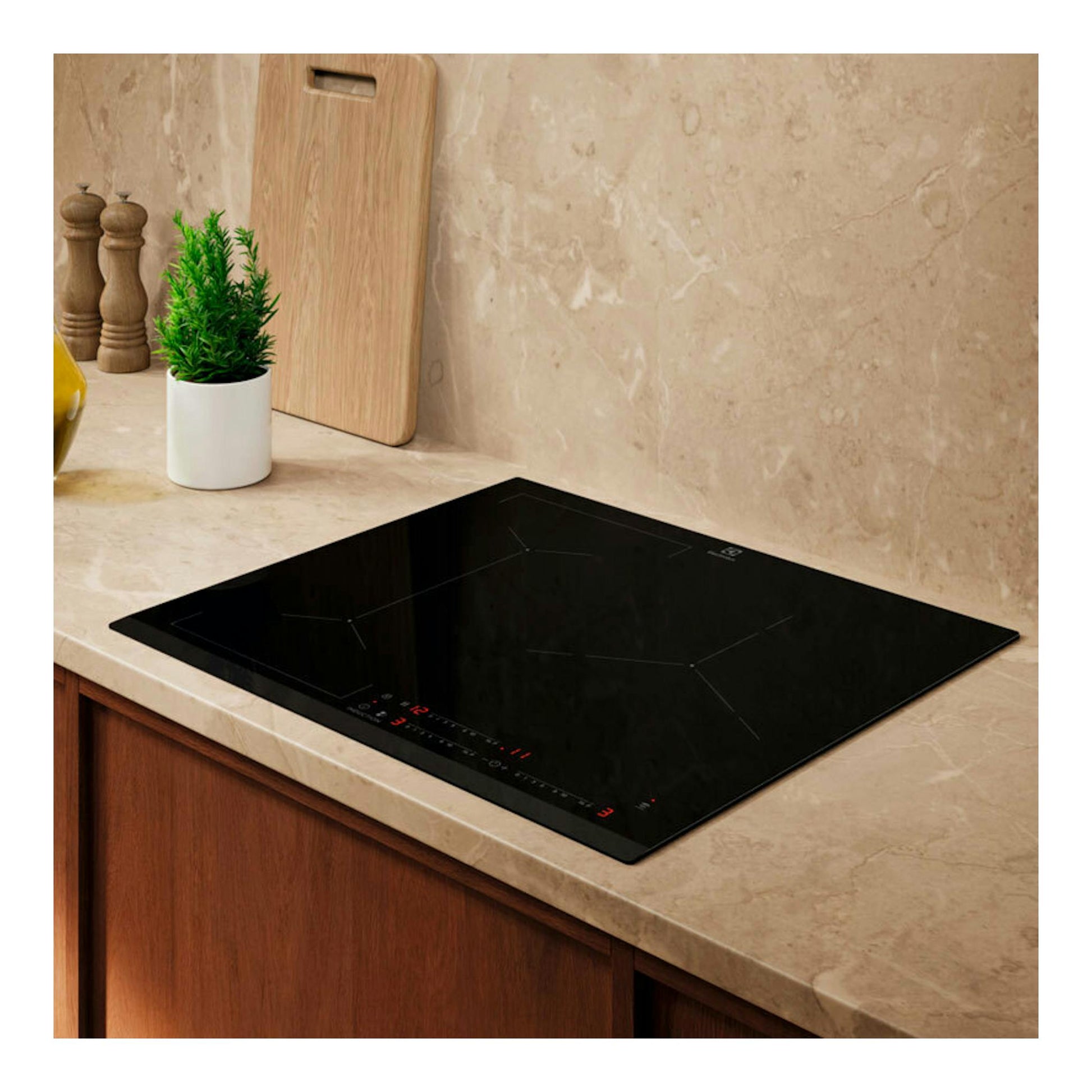Placa de inducción Electrolux EIV633 negra, vista en perspectiva sobre encimera de cocina.