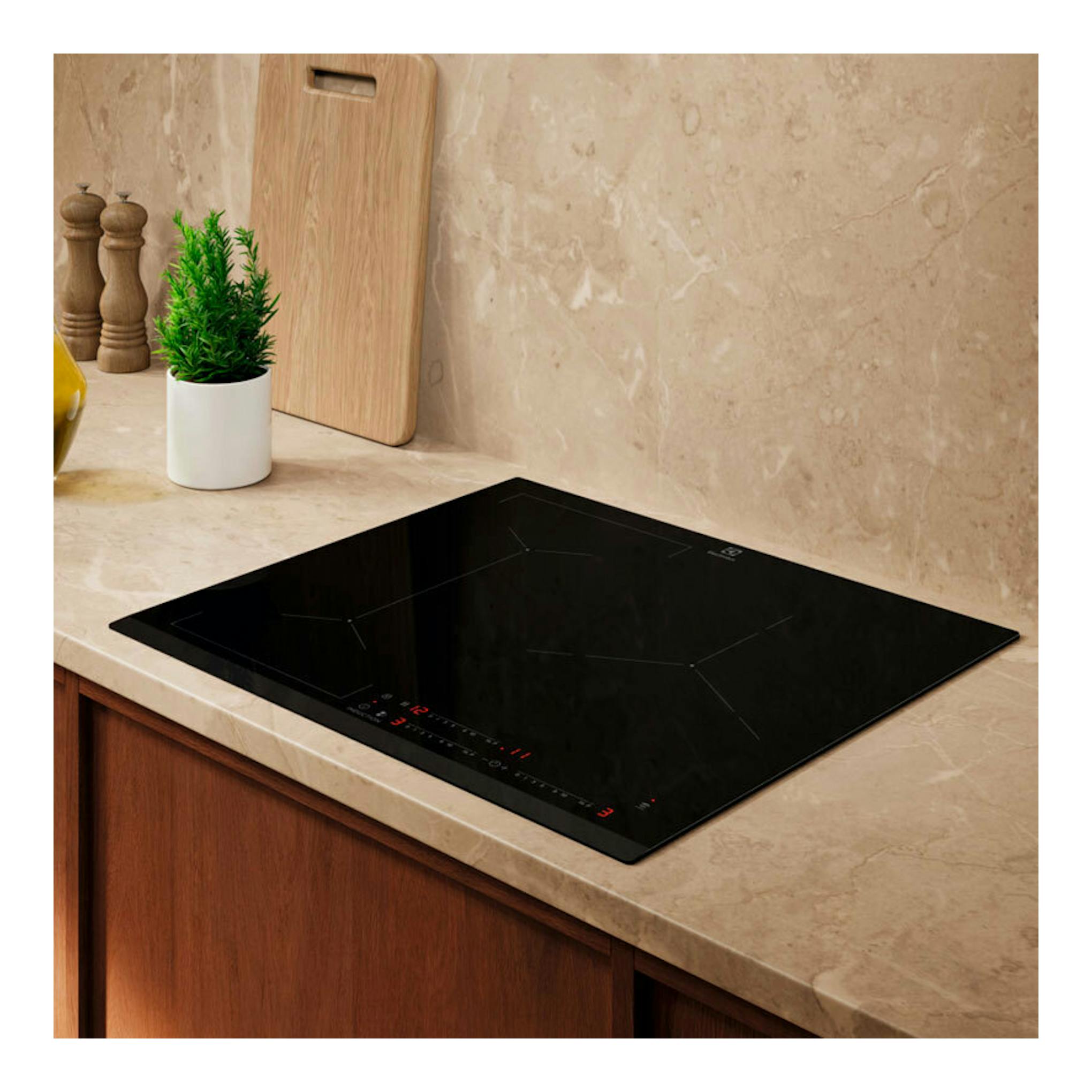 Placa de inducción Electrolux EIV633 negra, vista en perspectiva sobre encimera de cocina.