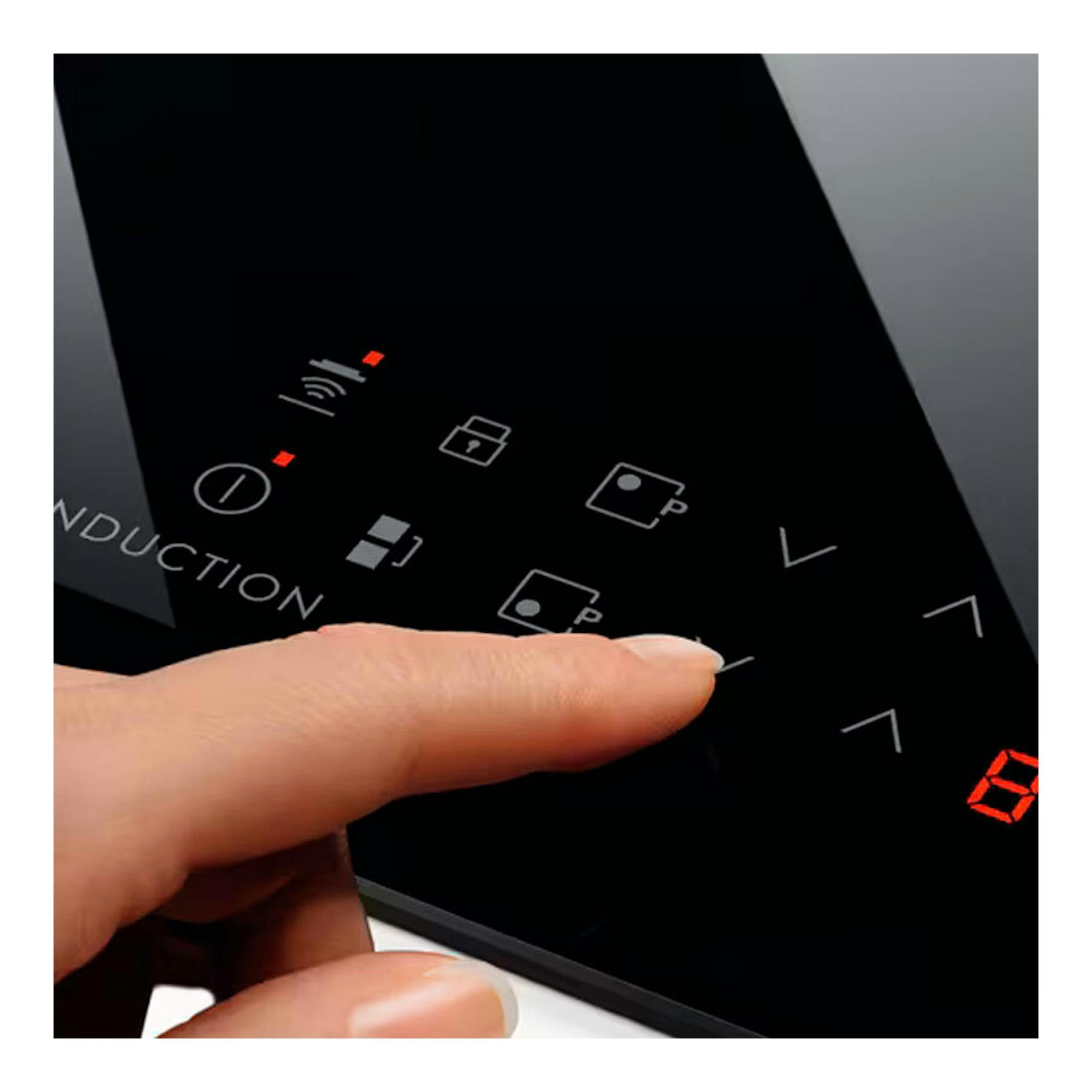Primer plano del panel táctil de la placa de inducción Electrolux LIT60336CK negra, con un dedo pulsando controles.